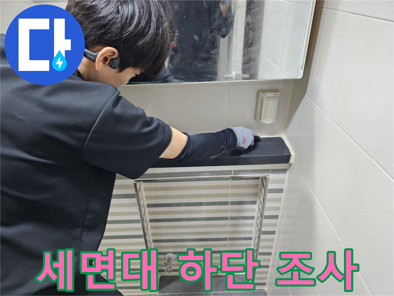 작업자가 세면대 선반 아래쪽을 손으로 만지며 확인하는 모습