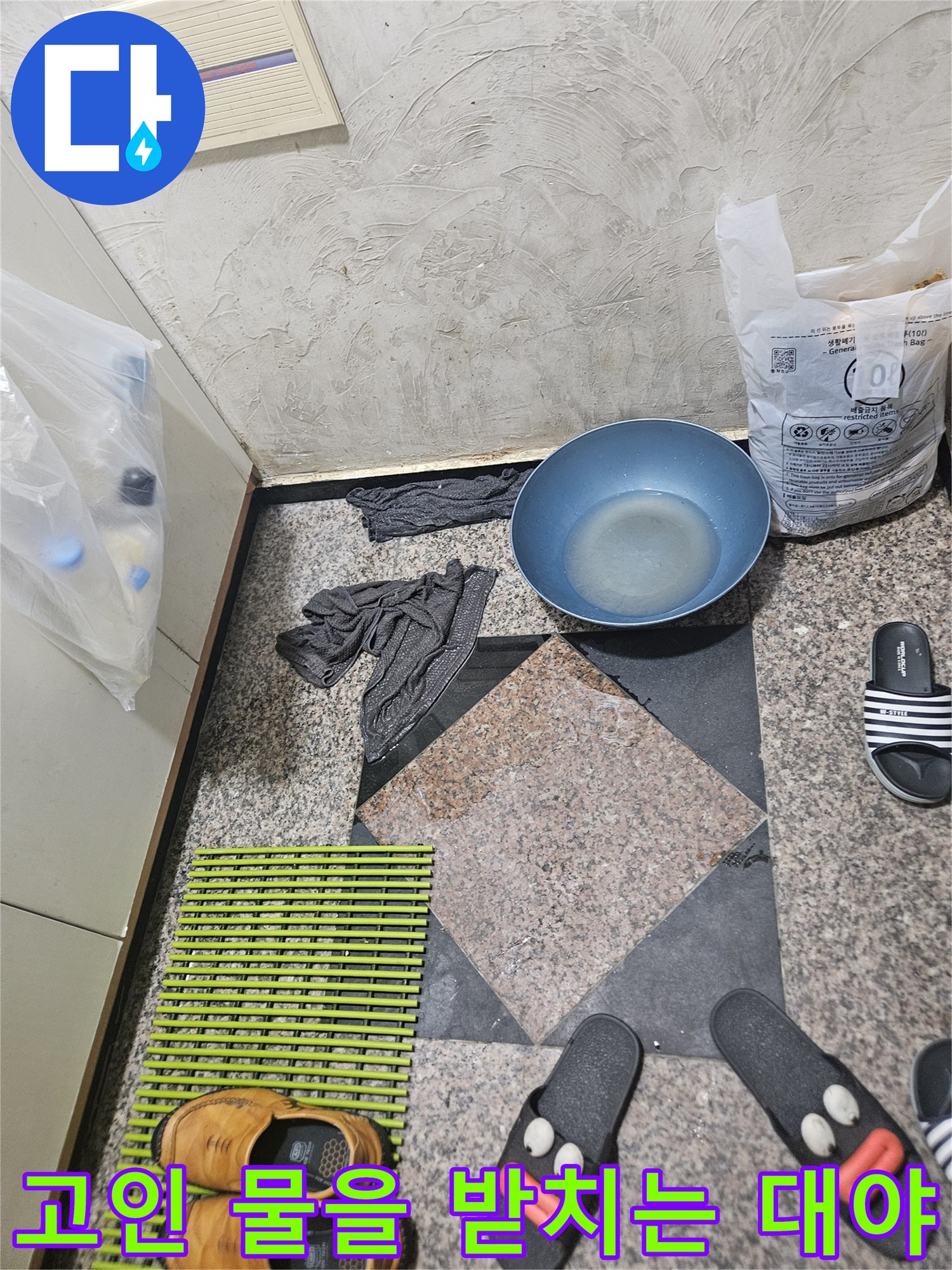 바닥에 고인 물을 받기 위해 설치된 파란색 용기