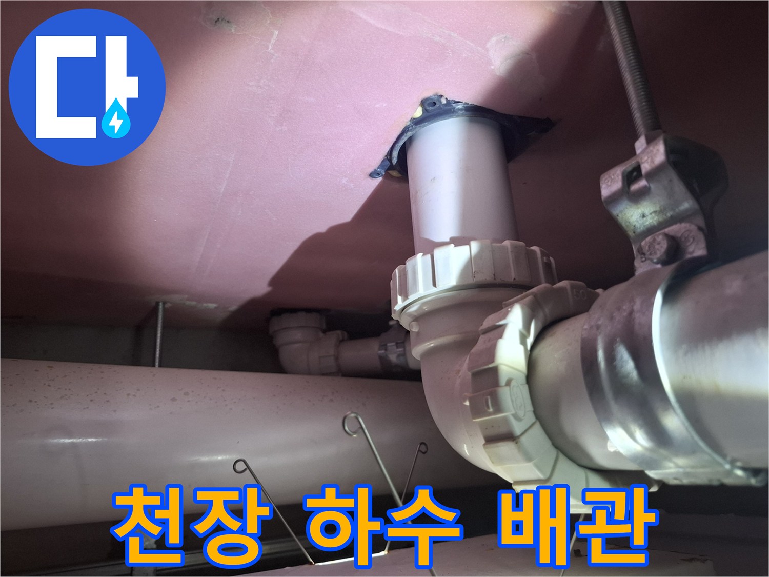 천장에 고정된 PVC 배관과 연결 부품들