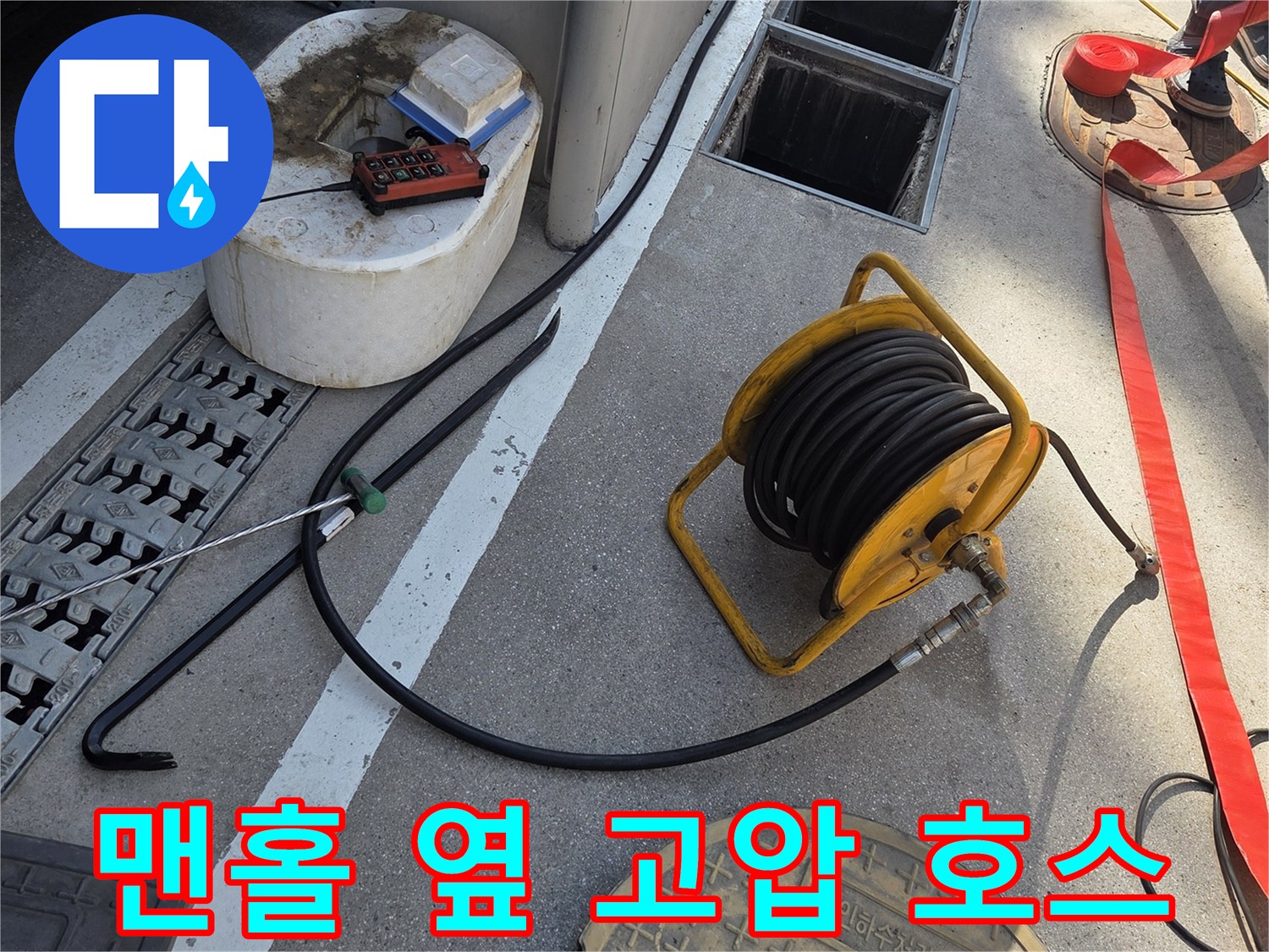 도로 맨홀 뚜껑과 나란히 놓인 노란색 세척 장비