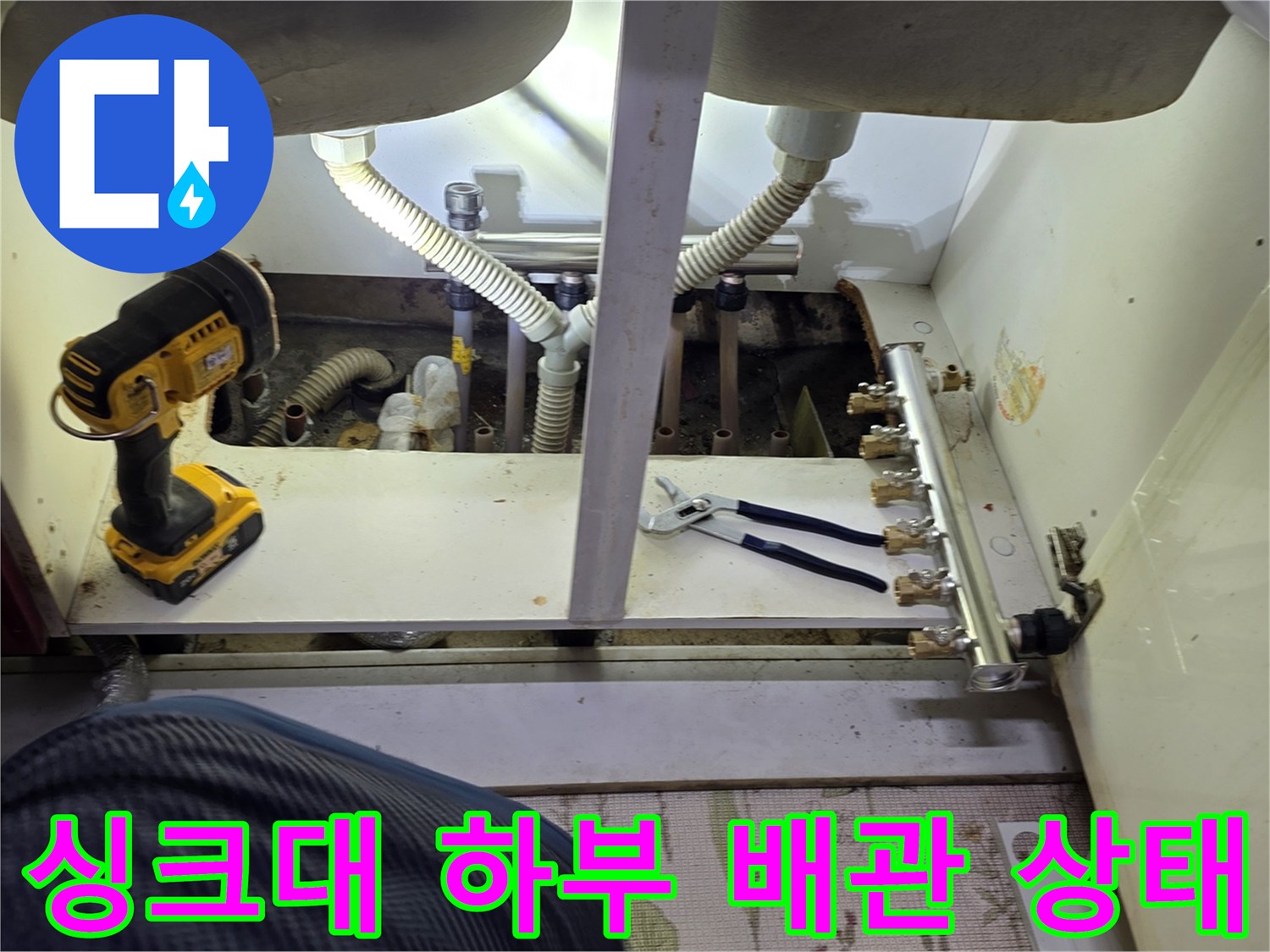 싱크대 아래 분배기와 연결된 다수의 배관들이 모여있는 모습입니다.