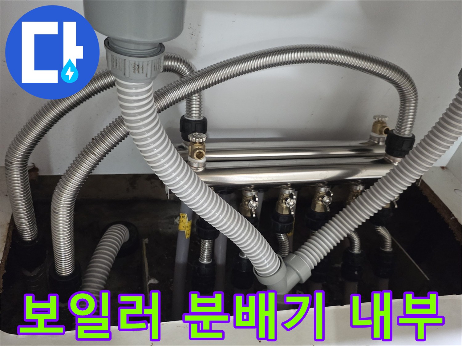 싱크대 아래 설치된 보일러 분배기와 연결 배관들의 모습