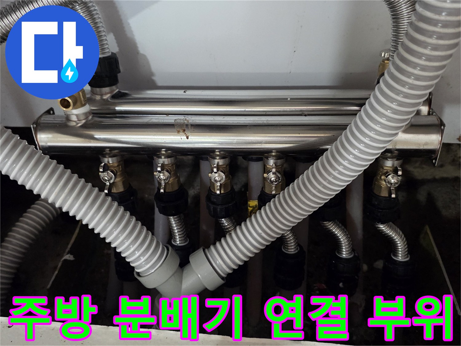싱크대 하부의 보일러 분배기와 연결된 다수의 은색 주름 배관들