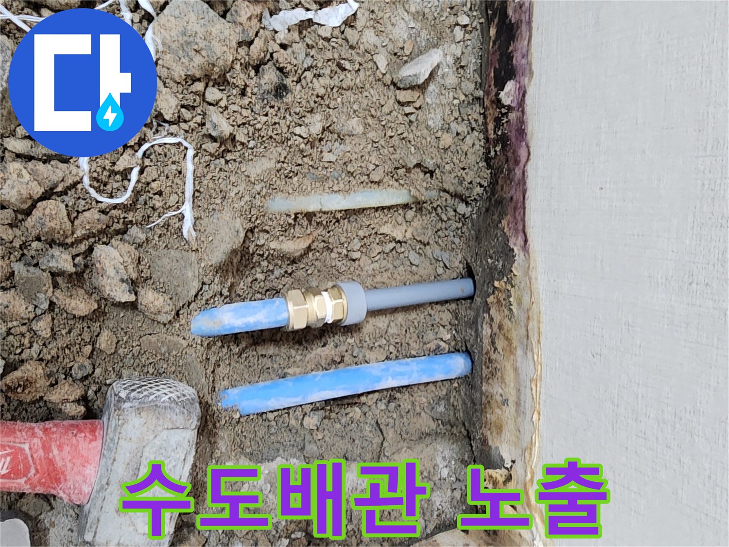 바닥 흙 속에 드러난 파란색 PB 배관과 공구들