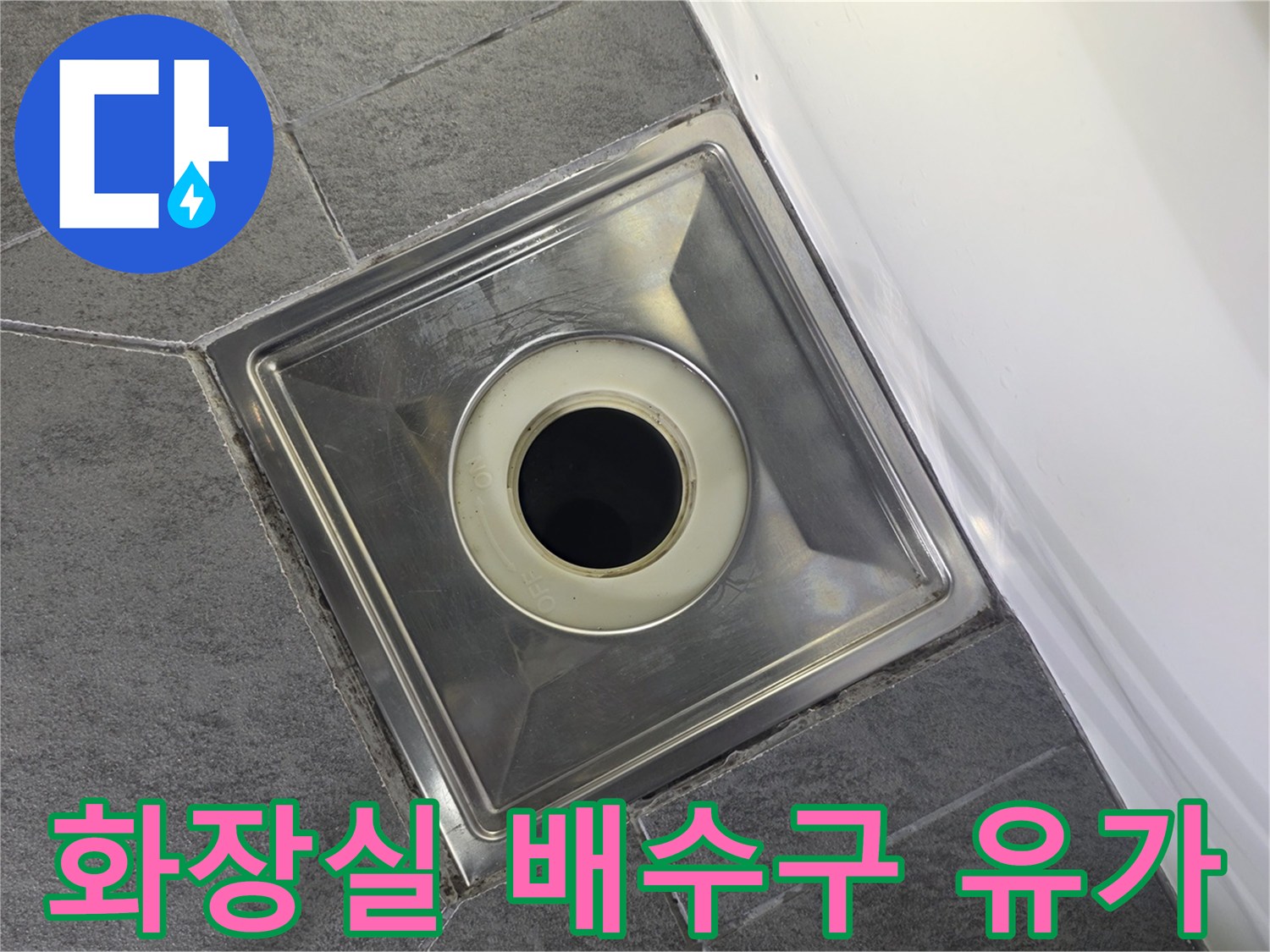 화장실 바닥 타일 사이의 스테인리스 유가 배수구 모습