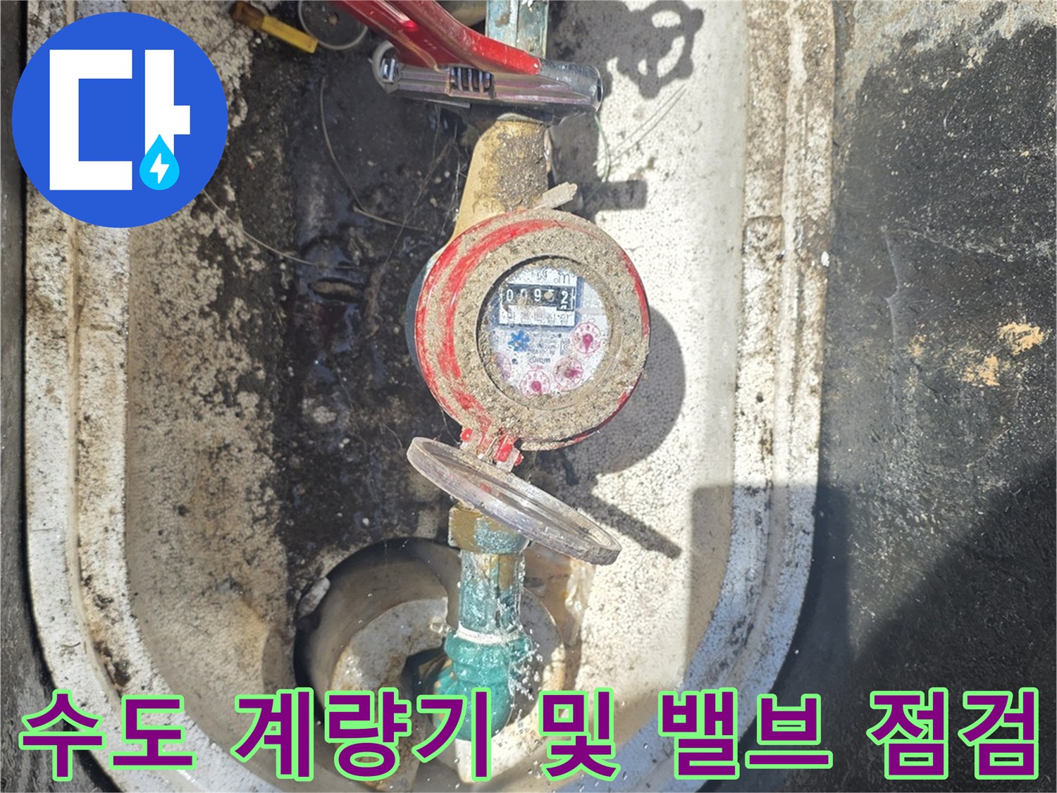 붉은색 핸들 밸브가 포함된 수도-계량기 장치 사진