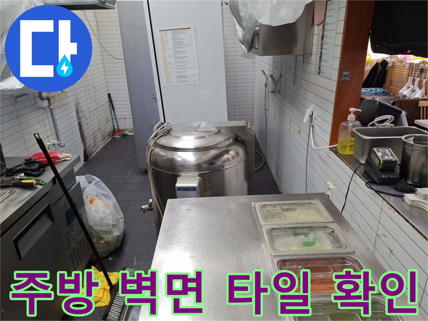 하얀색 타일로 마감된 주방 벽면과 하단 배관 연결 부위