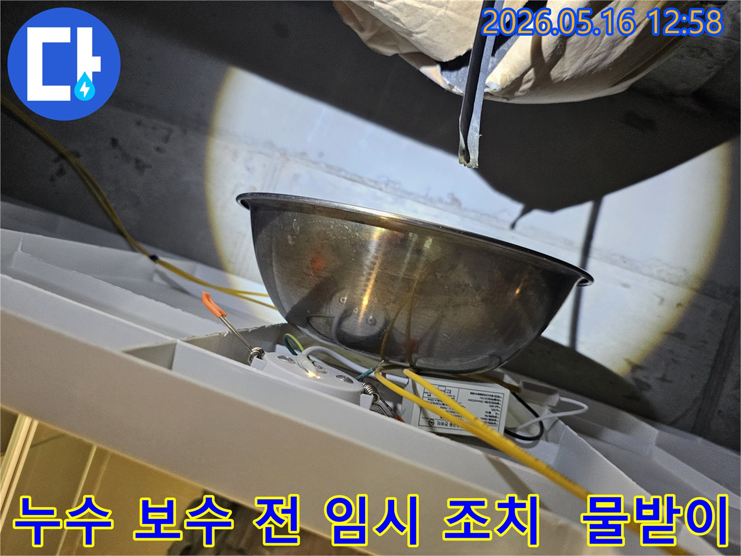 누수 보수 작업을 시작하기 전-천장에서 물이 떨어지는 것을-스테인리스 볼로-받아내며-주변의 전기 배선과-조명 장치를-보호하는 모습