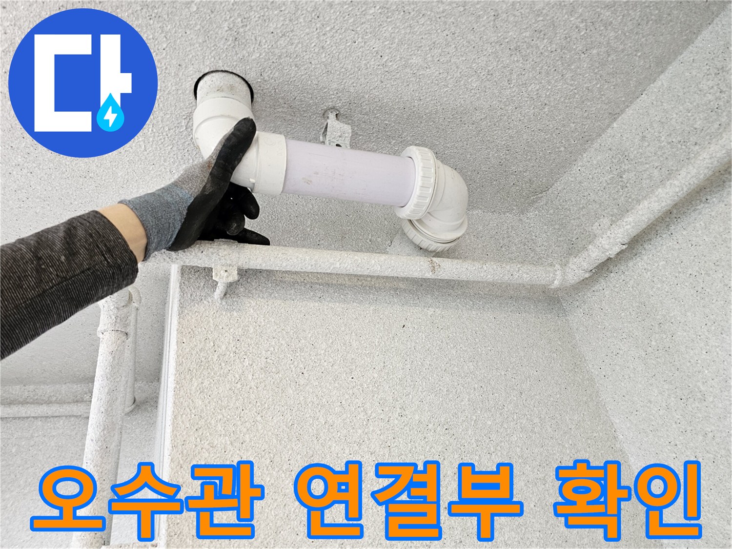 배수관 엘보 부위의 결합 상태를 직접 손으로 점검하고 있습니다.