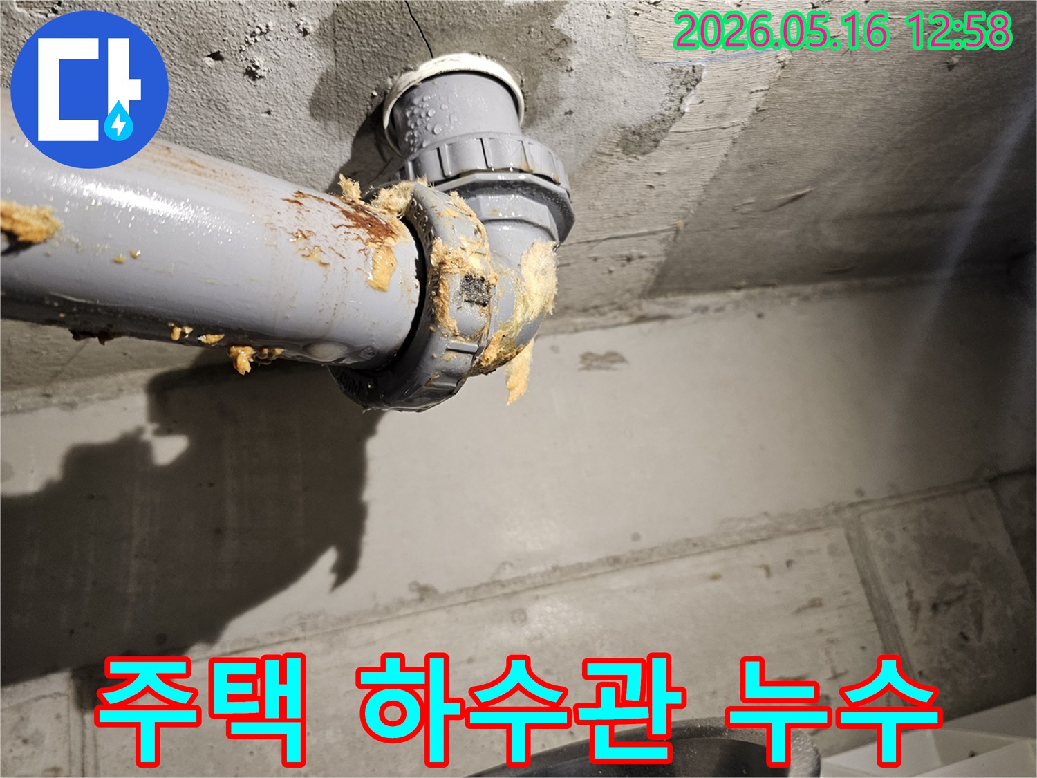 주택-천장-아래-하수관-연결부에서-물이-새어-나와-단열재가-젖은-모습을-보여주는-누수-현장-사진