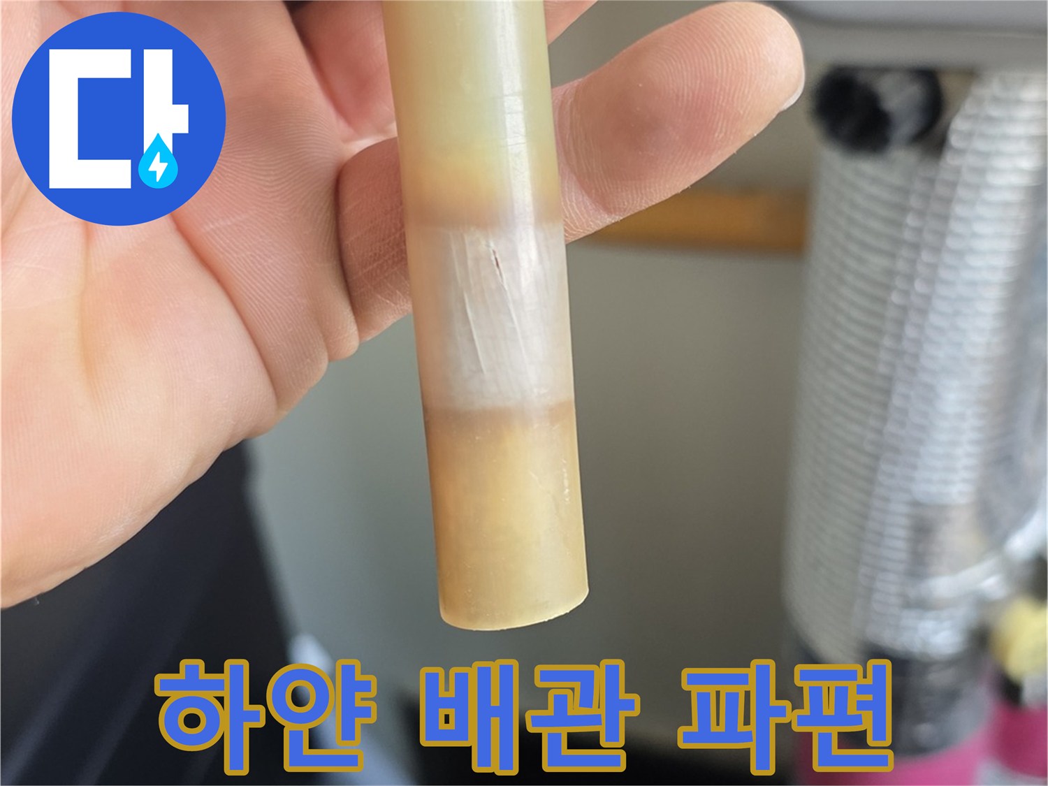 손으로 잡고 있는-파손되어 변색된 배관 조각