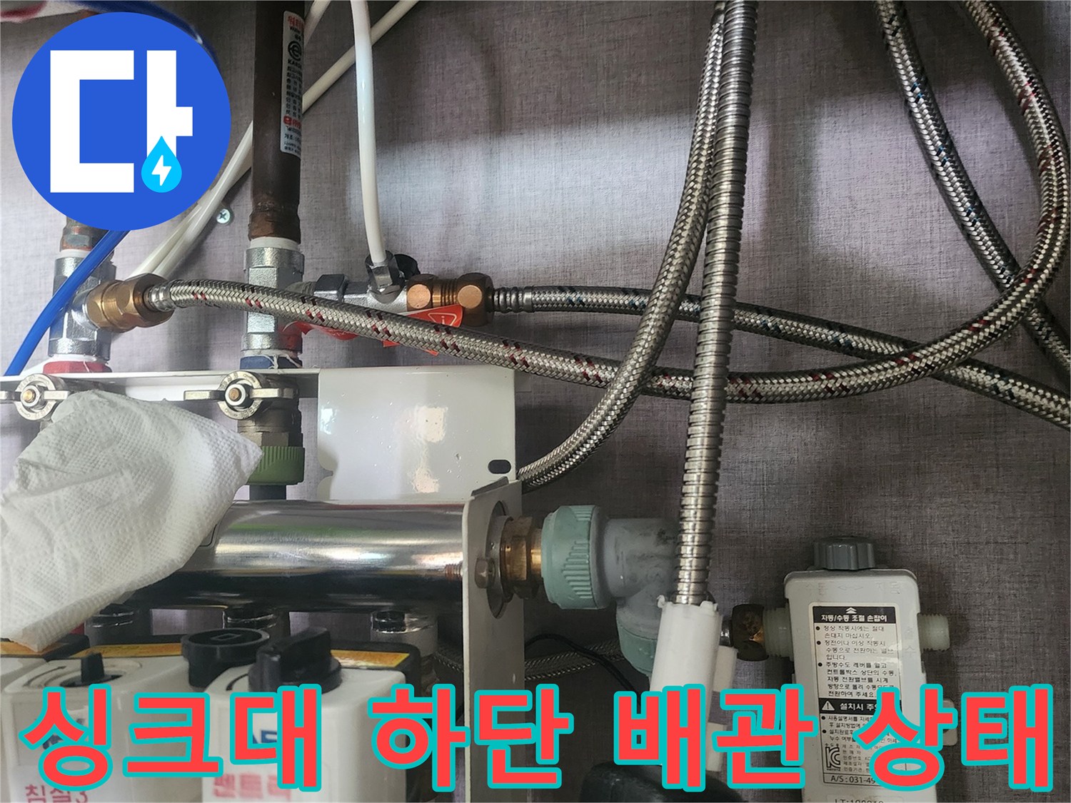 싱크대-하부의-은색-편사호스와-연결-부속품들