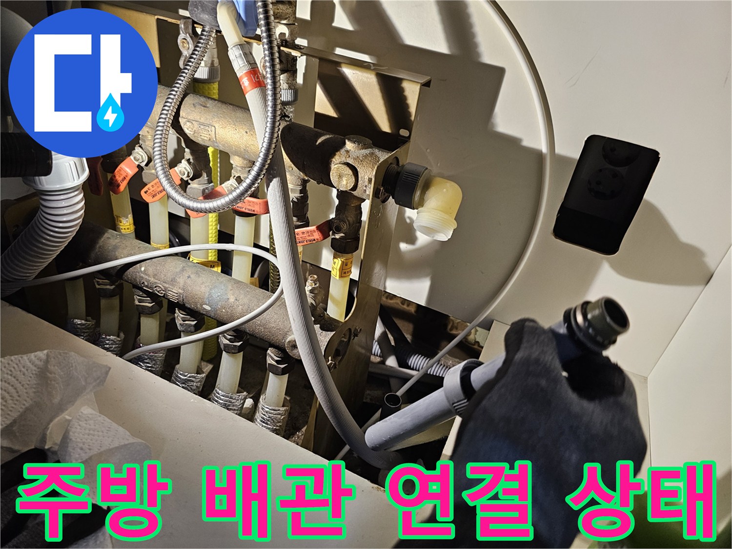 싱크대 아래 복잡한 구조의 배수 및 급수 배관 점검 모습
