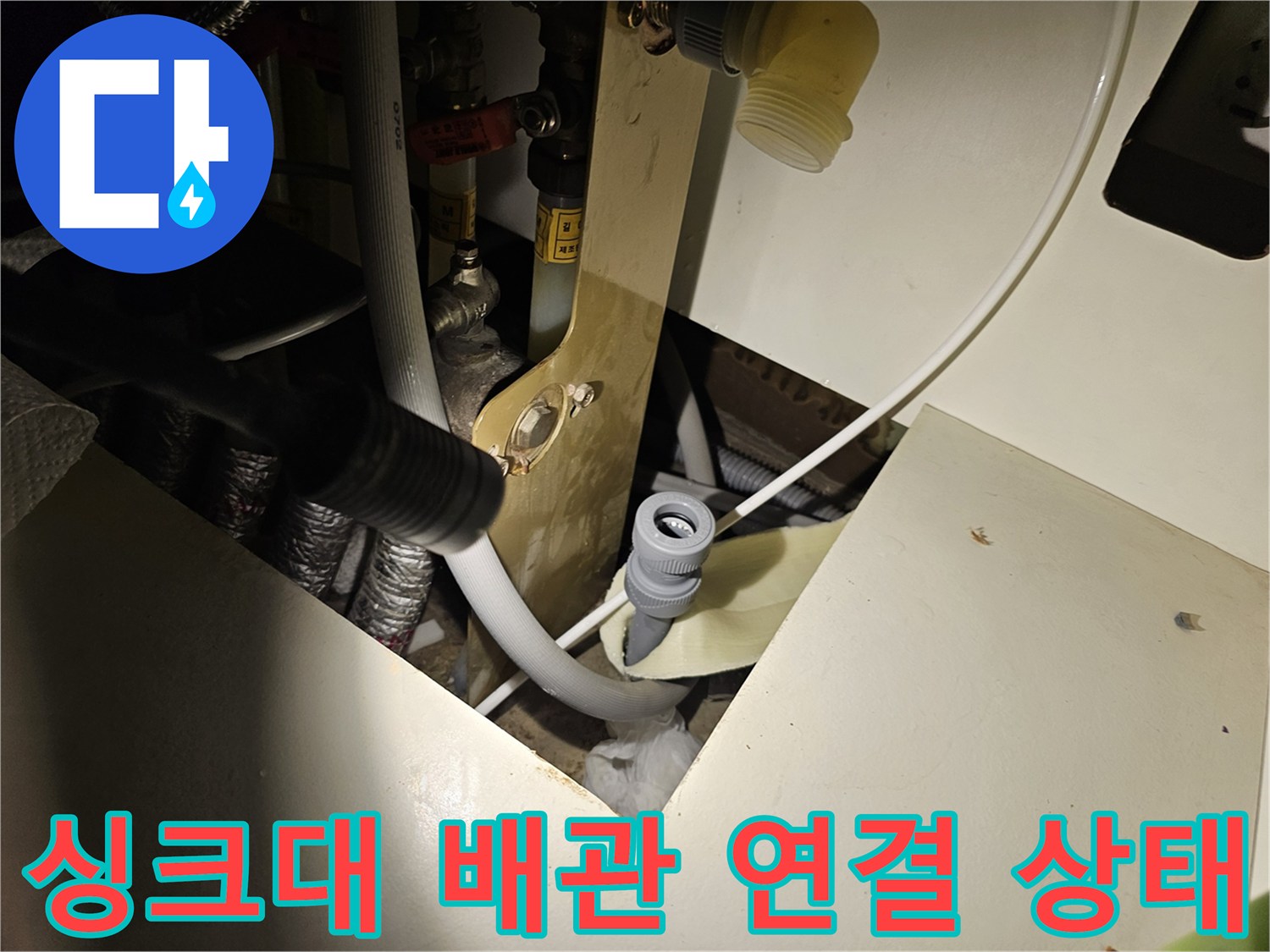 싱크대 하부장 내부의 배수 배관과 연결 부위 근접 사진