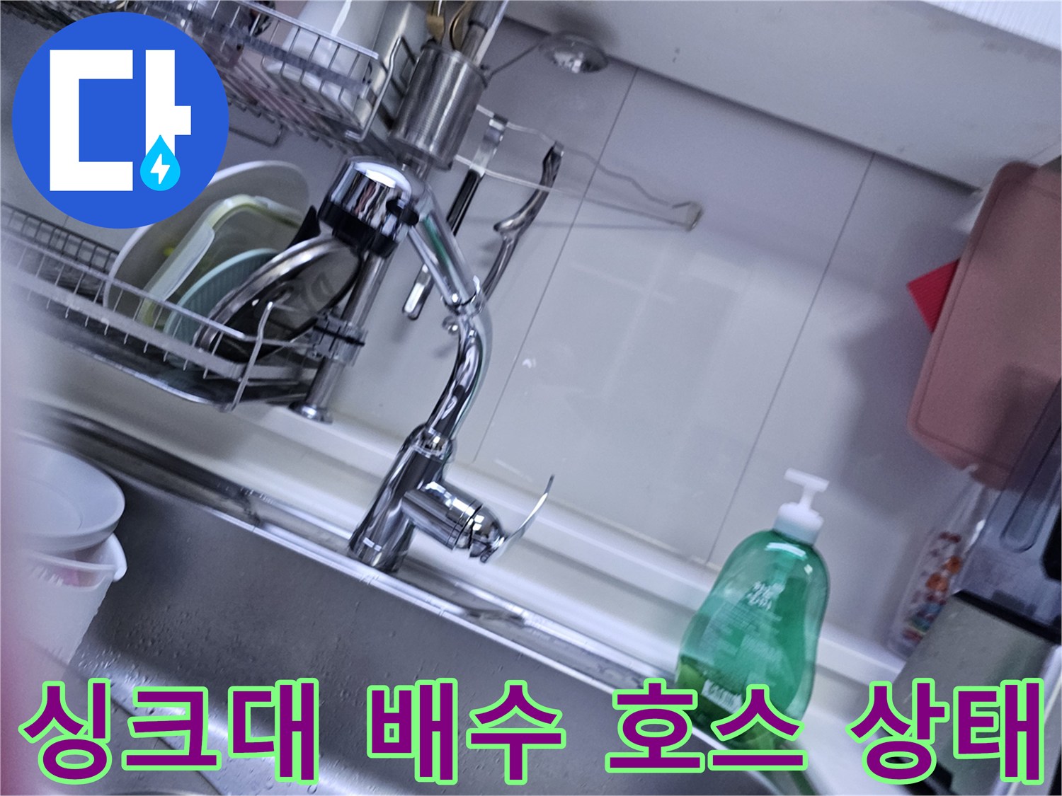 주방 하부장 내부의 굽어진 배수 호스와 연결 부위 촬영