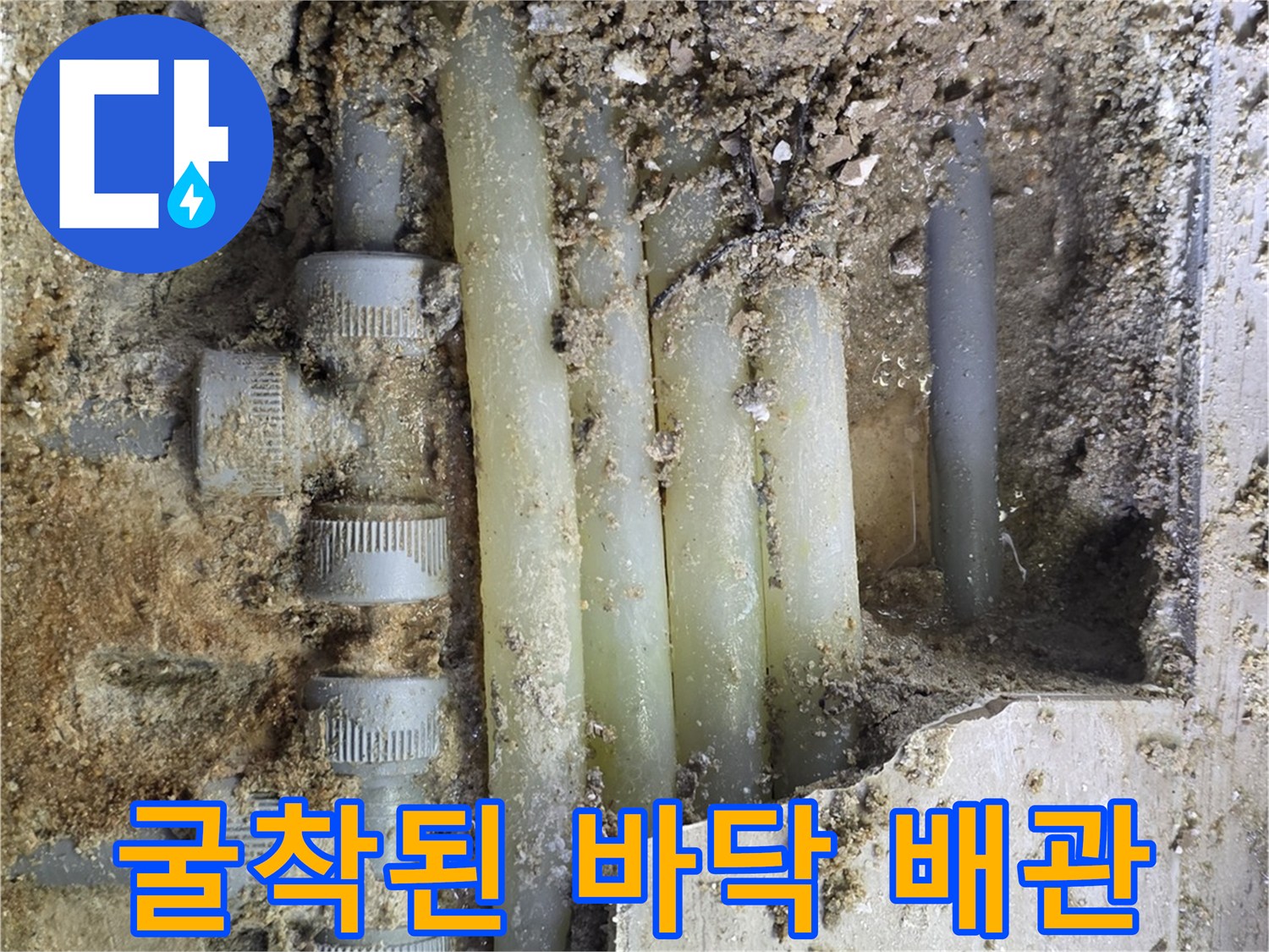 흙과 파편 사이에 노출된 누수 발생 배관 부속