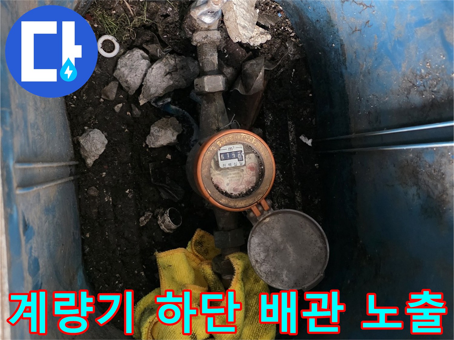 파란색 계량기 함 내부의 젖은 흙과 배관 부속