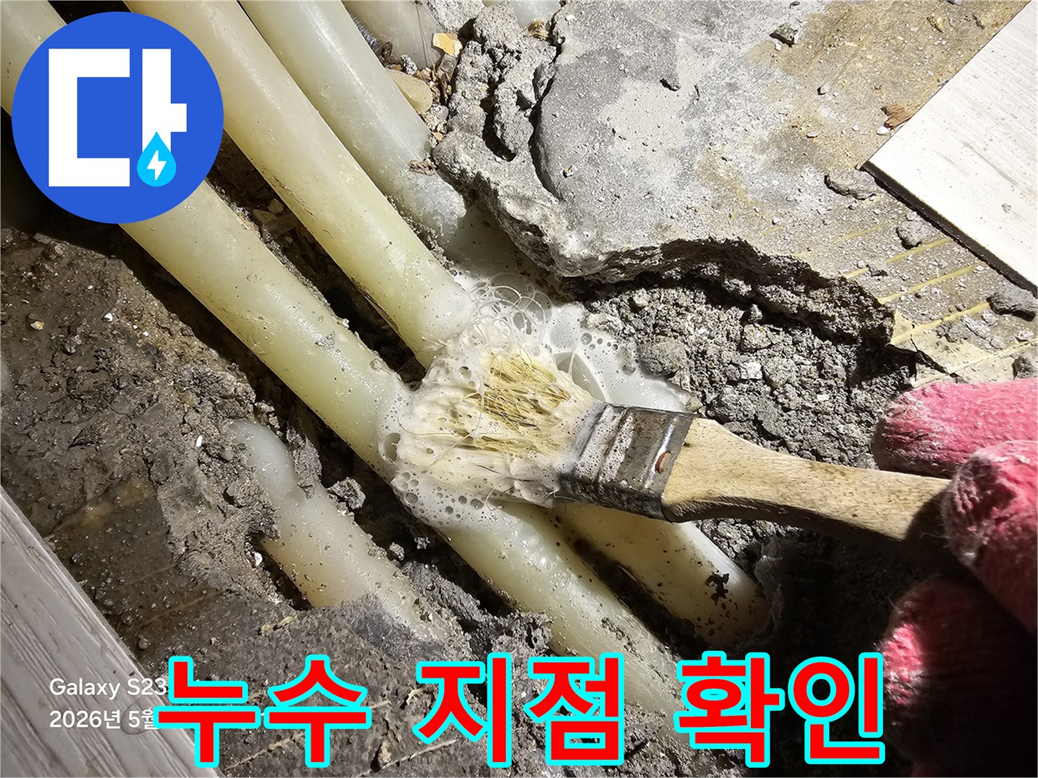 배관 주변의 젖은 콘크리트와 작업용 붓