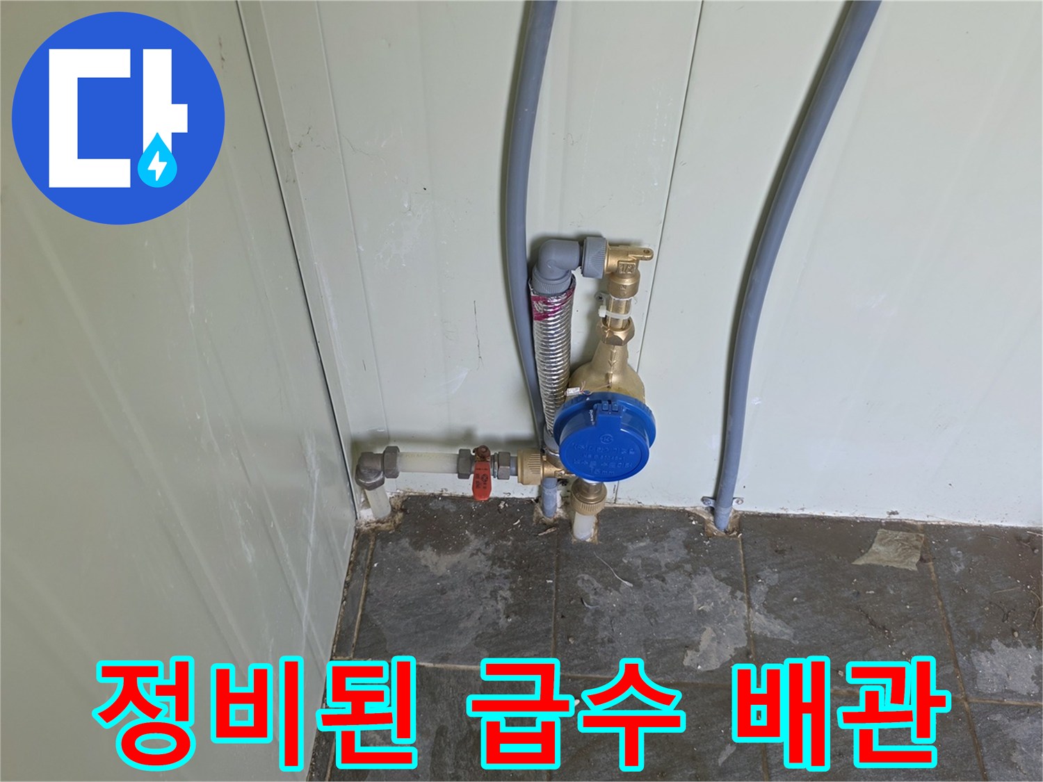 벽면을 타고 올라가는 회색 급수 호스와 계량기 연결 부위