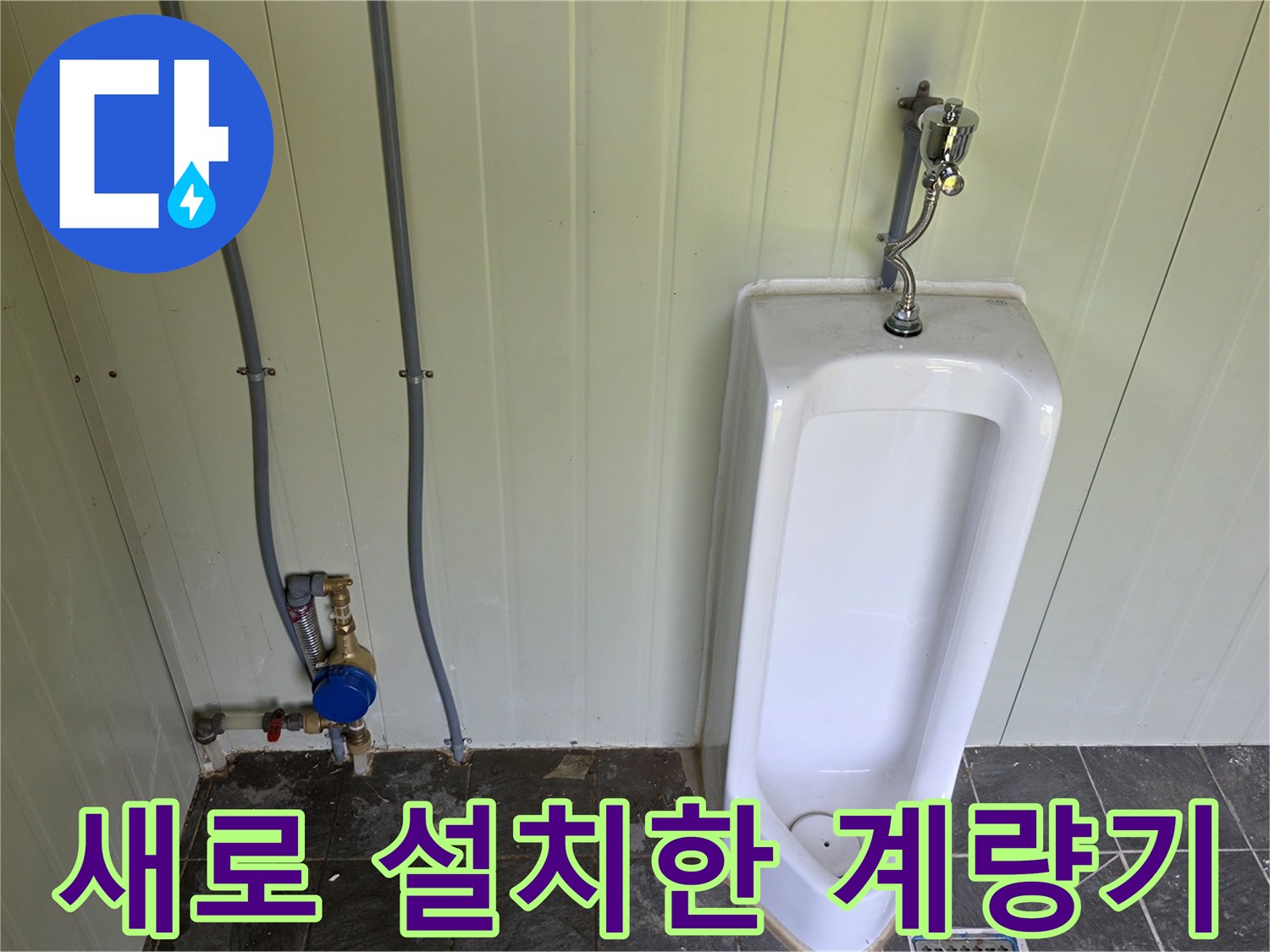 소변기 옆 배관에 부착된 파란색 수도 계량기