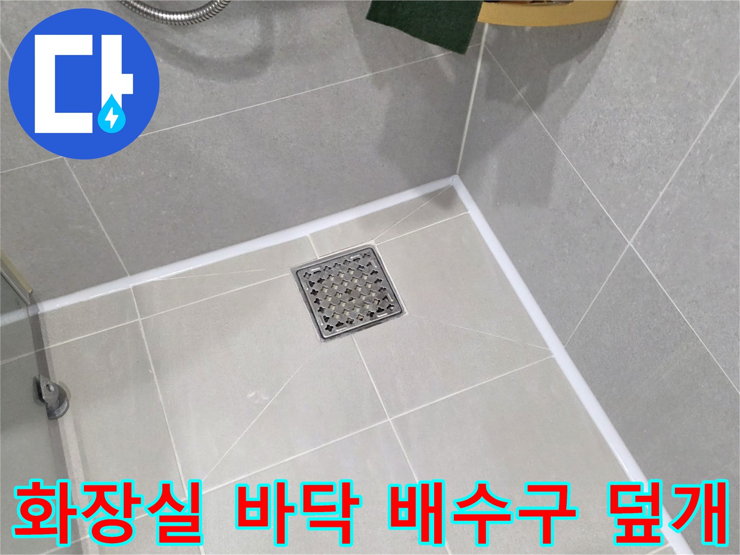 밝은 회색 타일로 구성된 욕실의 배수구 부위