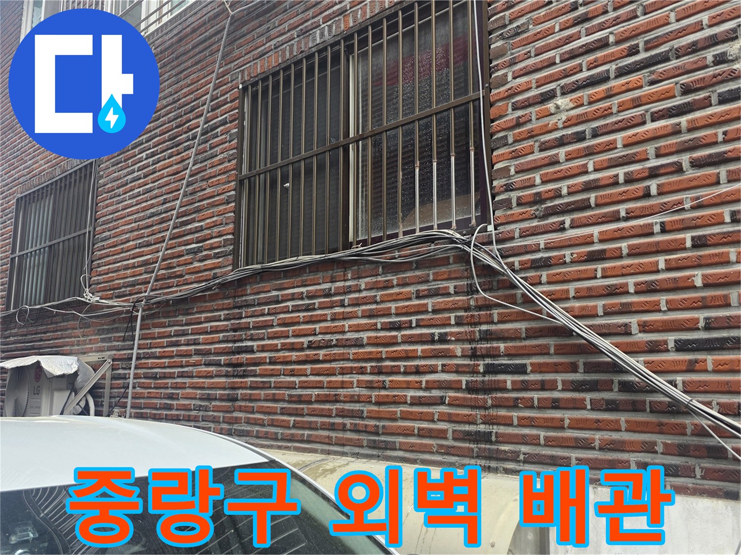 중랑구 건물-창문 아래 벽돌 벽면의 외부 배관