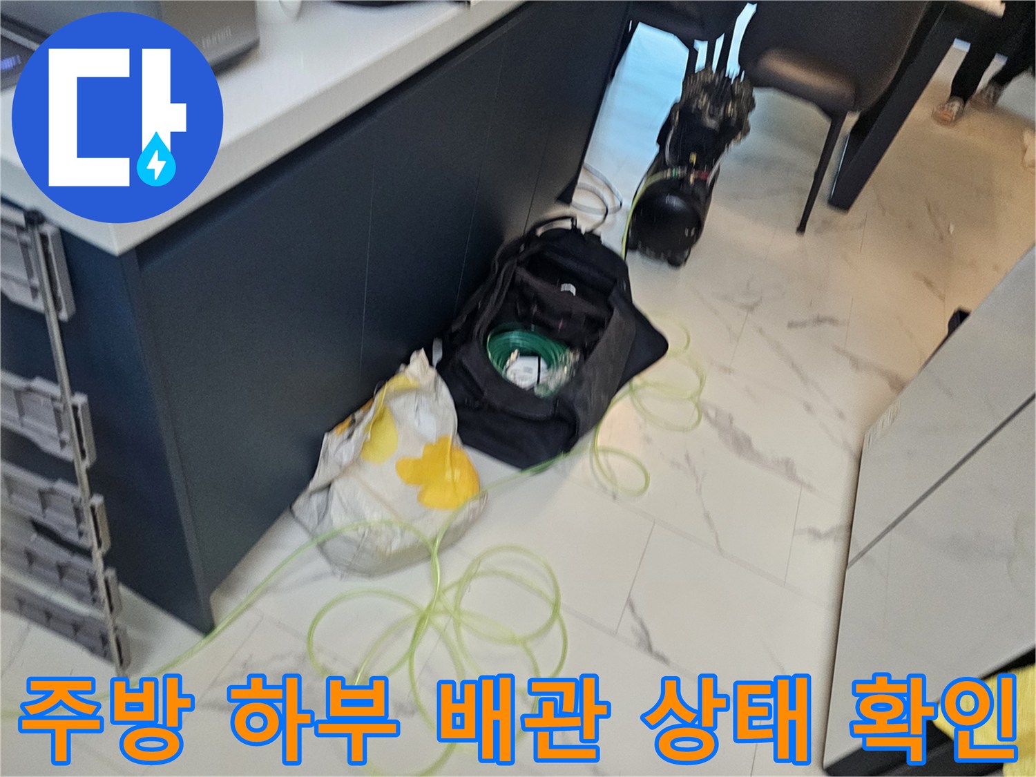 싱크대 아래쪽 배관 주변의 작업 환경과 장비들