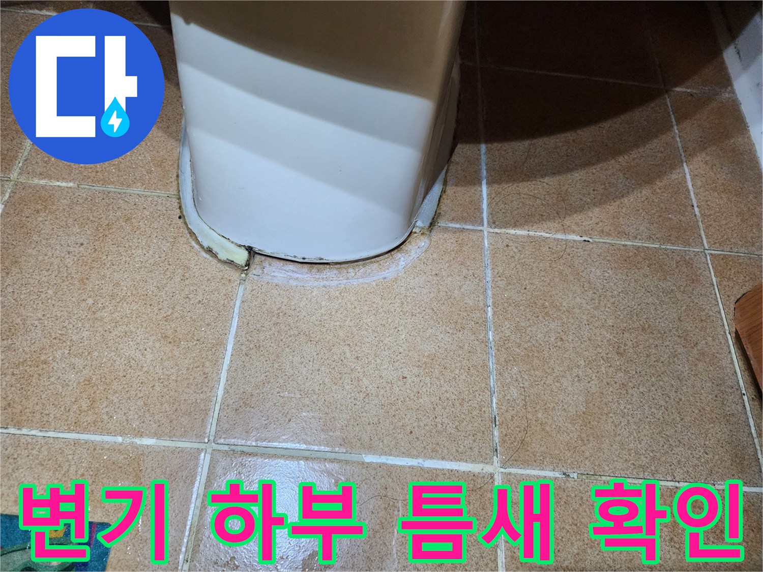변기 주변 타일 사이의 벌어진 공간을 촬영한 사진입니다.
