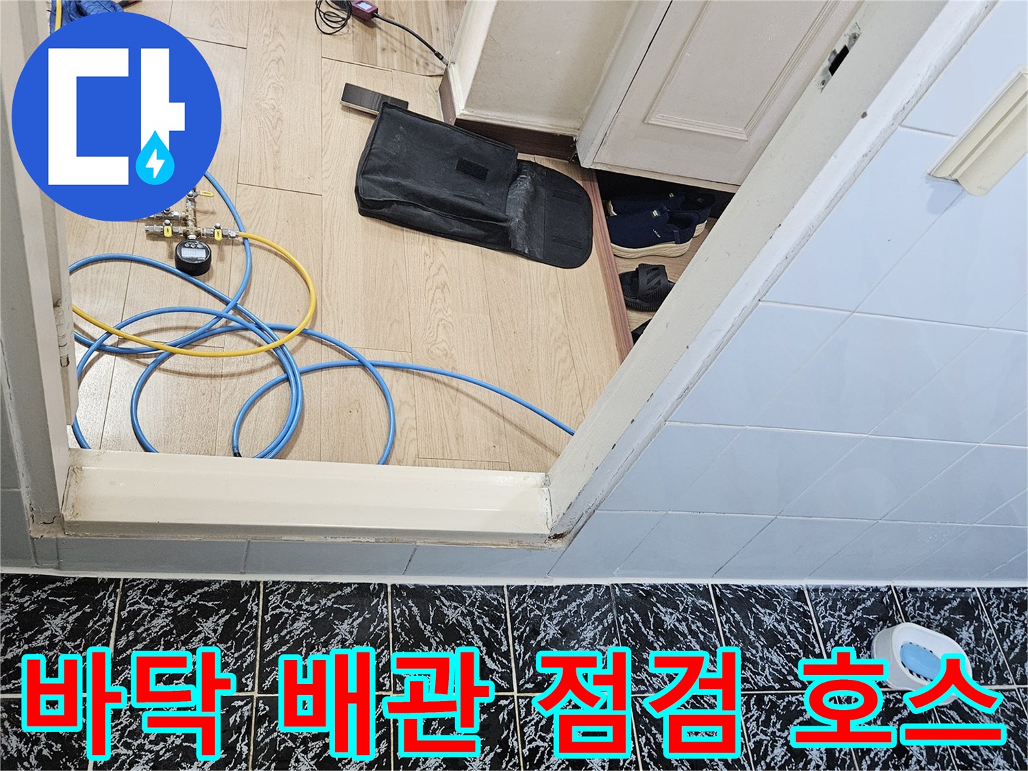 검은색-타일-바닥과-노란색-파란색-배관-점검용-호스