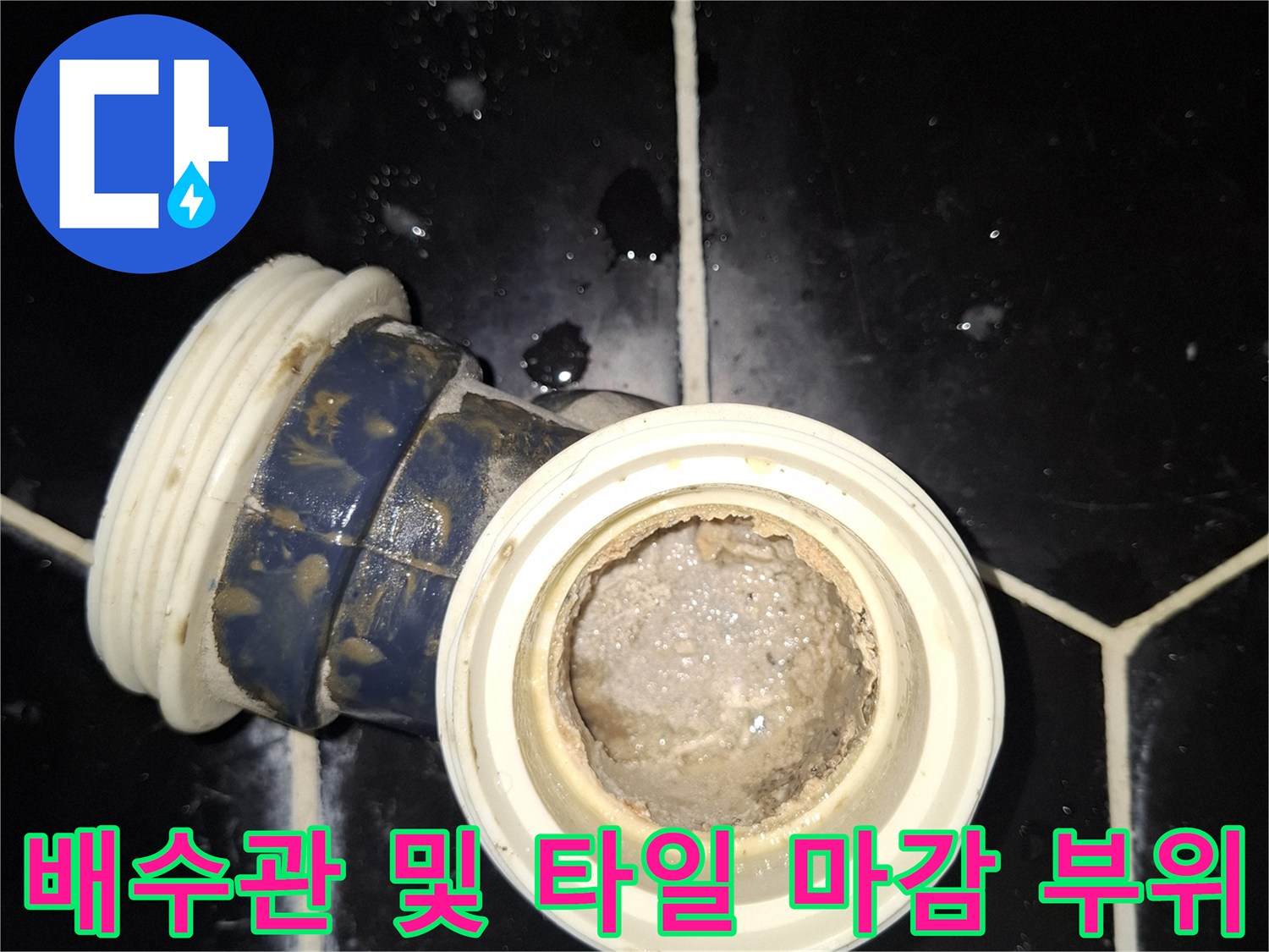 검정 육각 타일과 화장실 배수 부속의 접합 부분