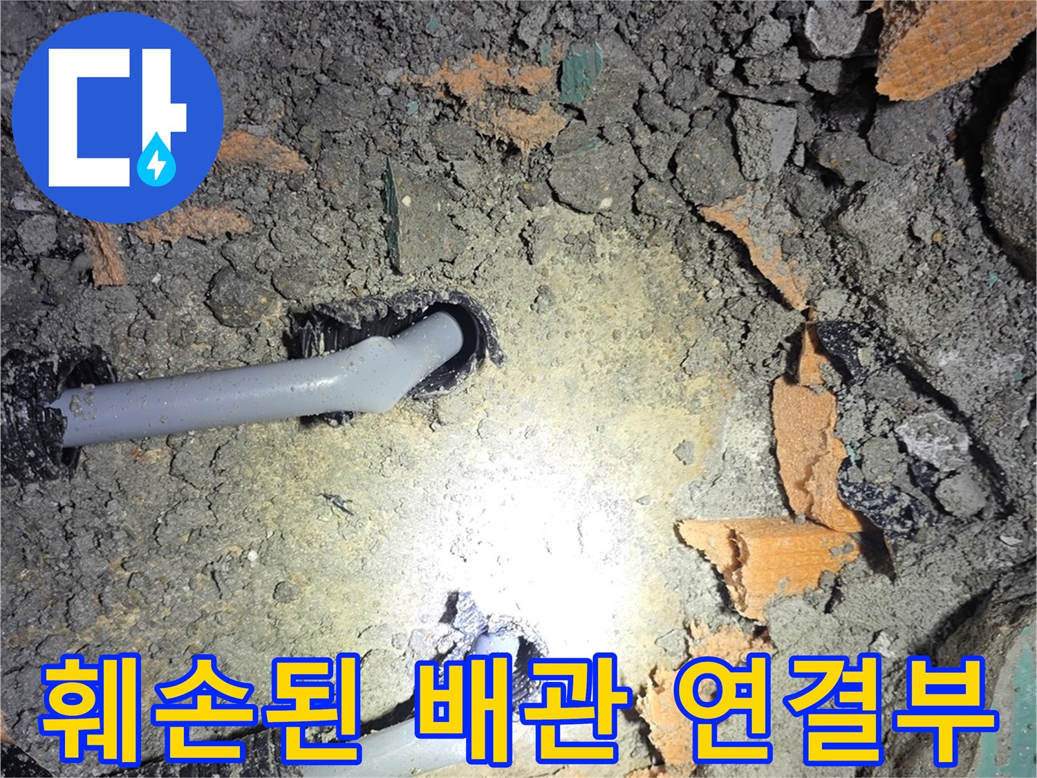 콘크리트 아래 드러난-파손된 회색 에이콘 파이프