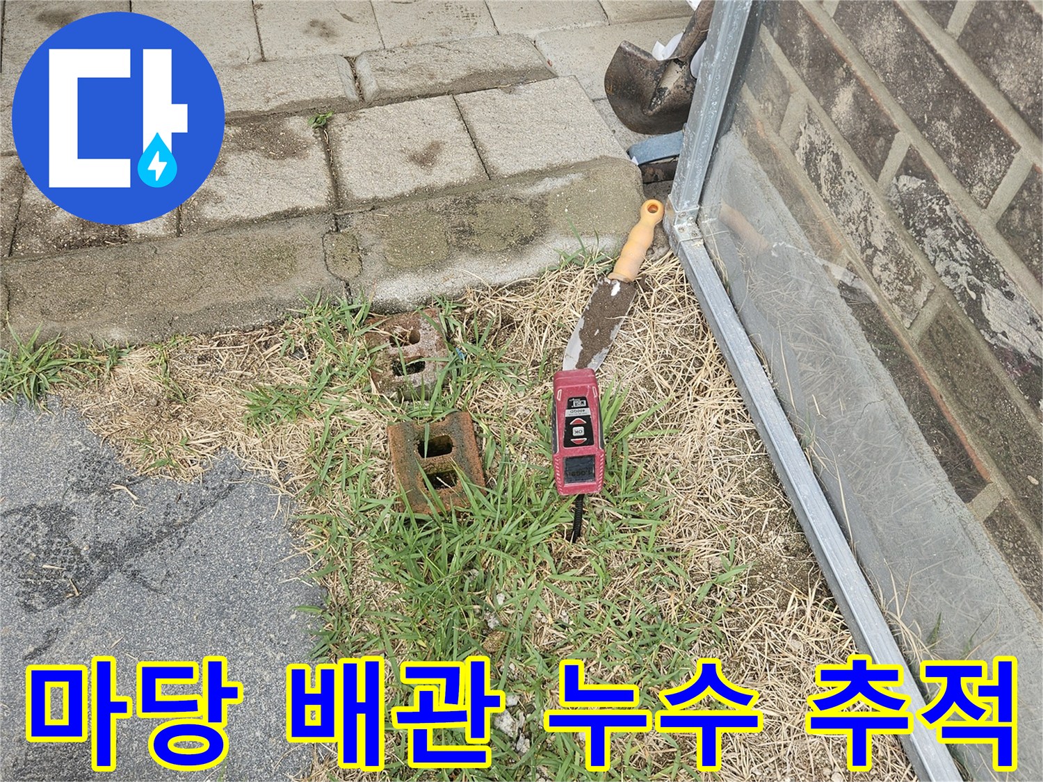 외부 수도 부근의 흙 위에서 가스 탐지기로 이상 지점을 찾는 모습입니다.