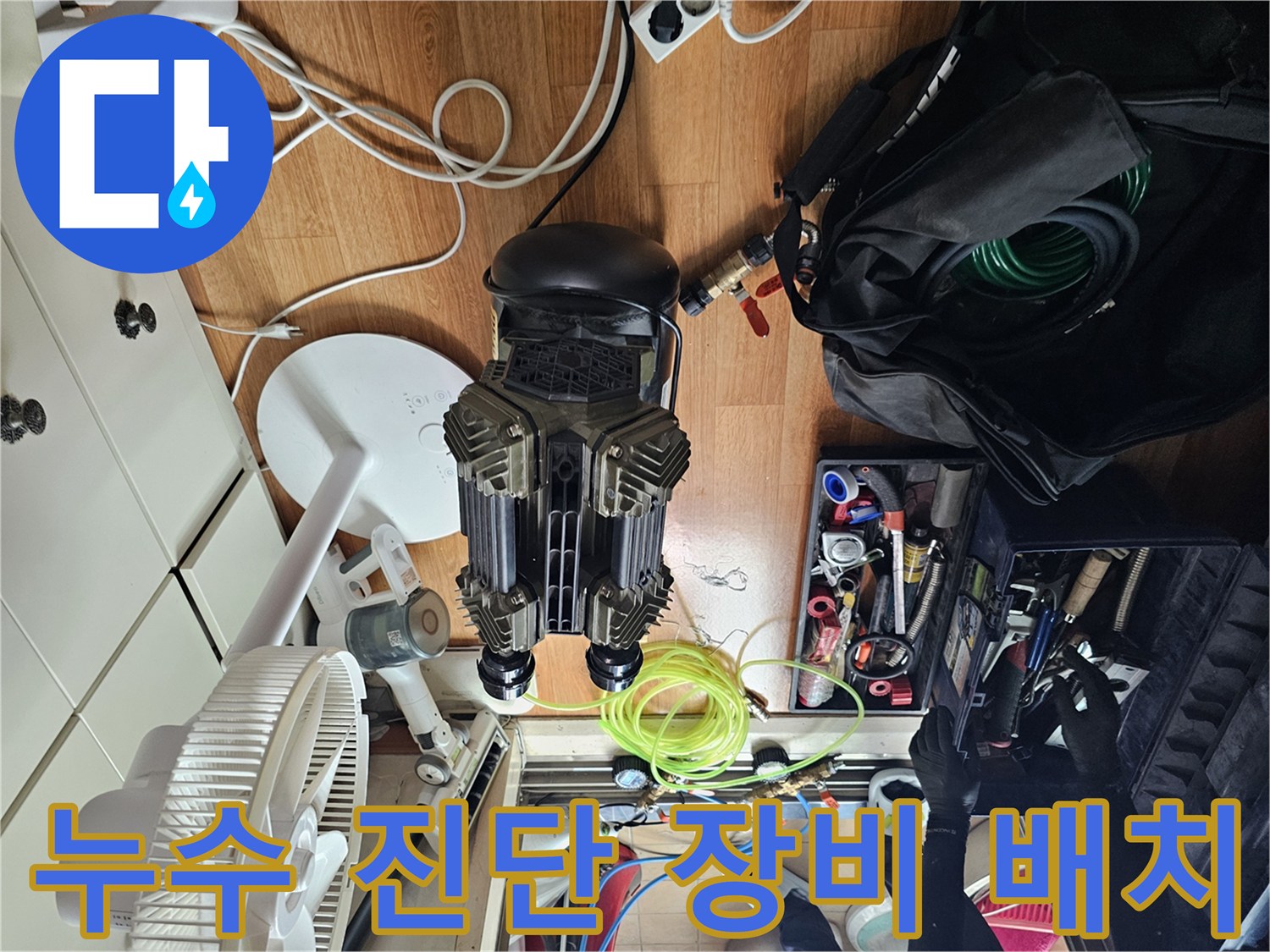 싱크대 하부 누수 확인을 위해 바닥에 세팅된 각종 검사 도구와 호스