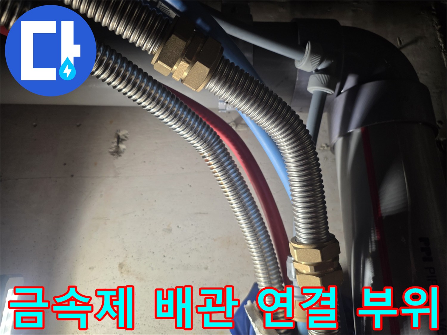 은색 주름관과 황동색 너트가 결합된 배관 상세샷