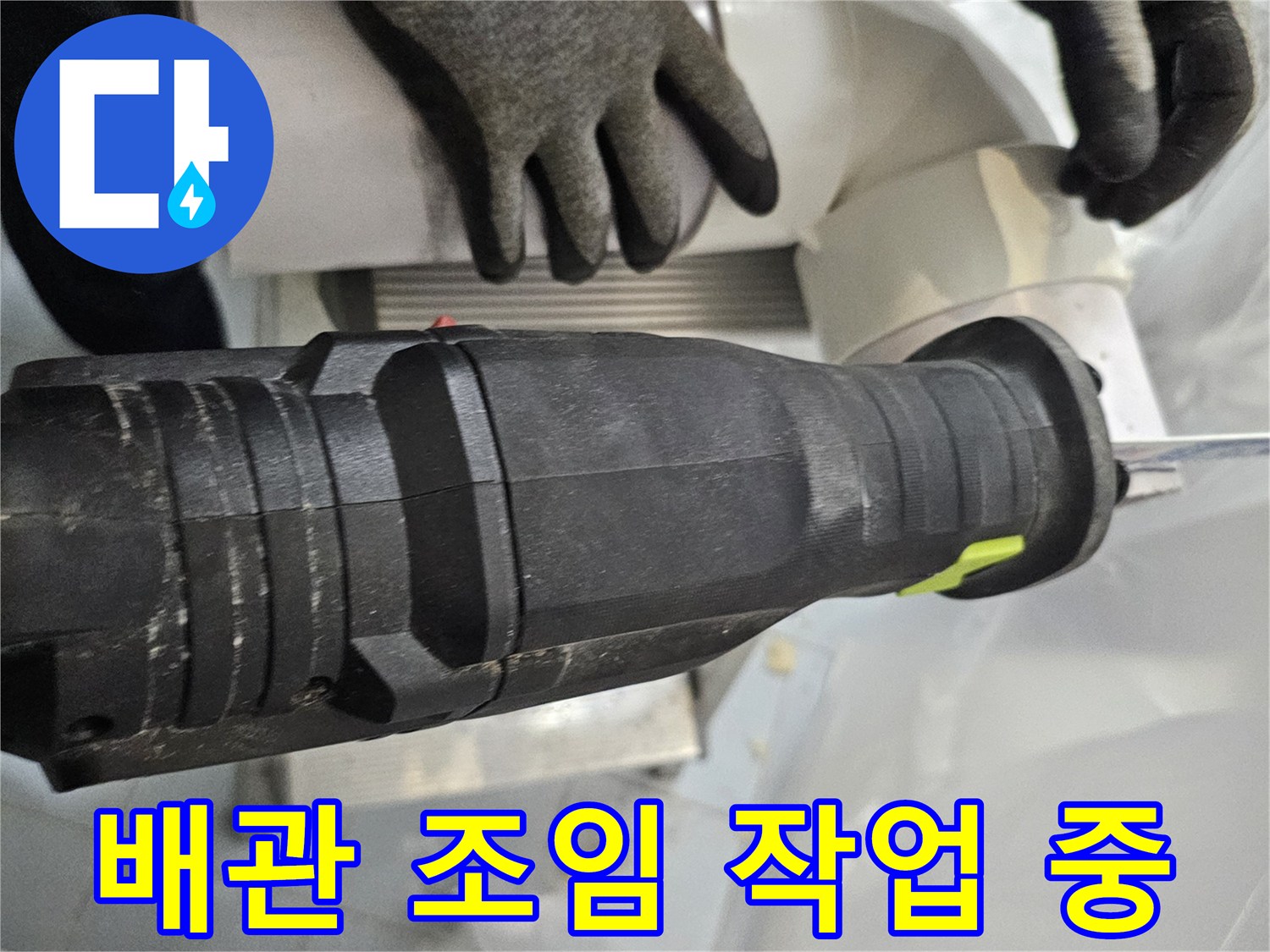 새로 설치한-배관 연결부를-전동 공구로 고정하는 모습