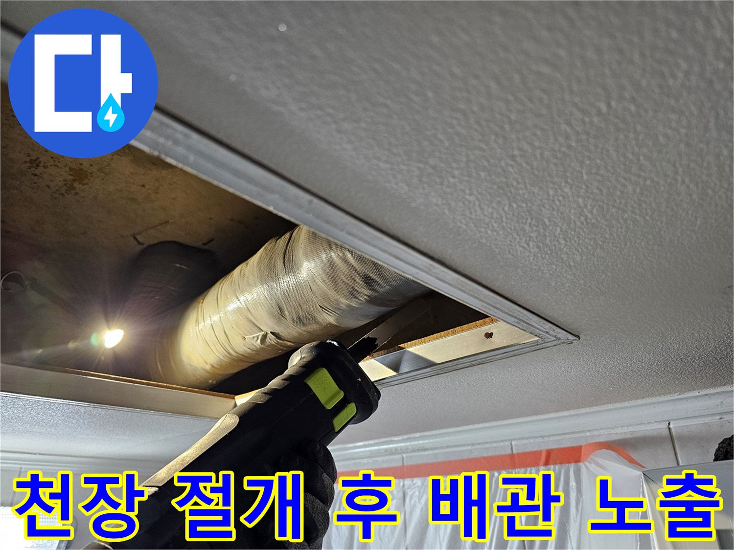 천장 틈새를 통해 보이는 노후된 배관과 작업 현장 상황