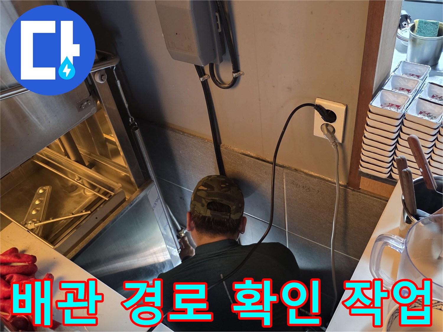 좁은 싱크대 하부 공간에서 배관 상태를 살피는 모습