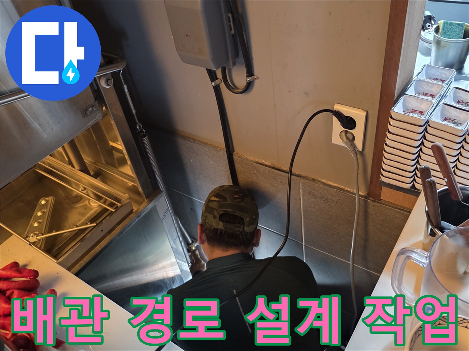 좁은 주방 하부 공간에서 배관 신설을 위해 작업 중인 모습