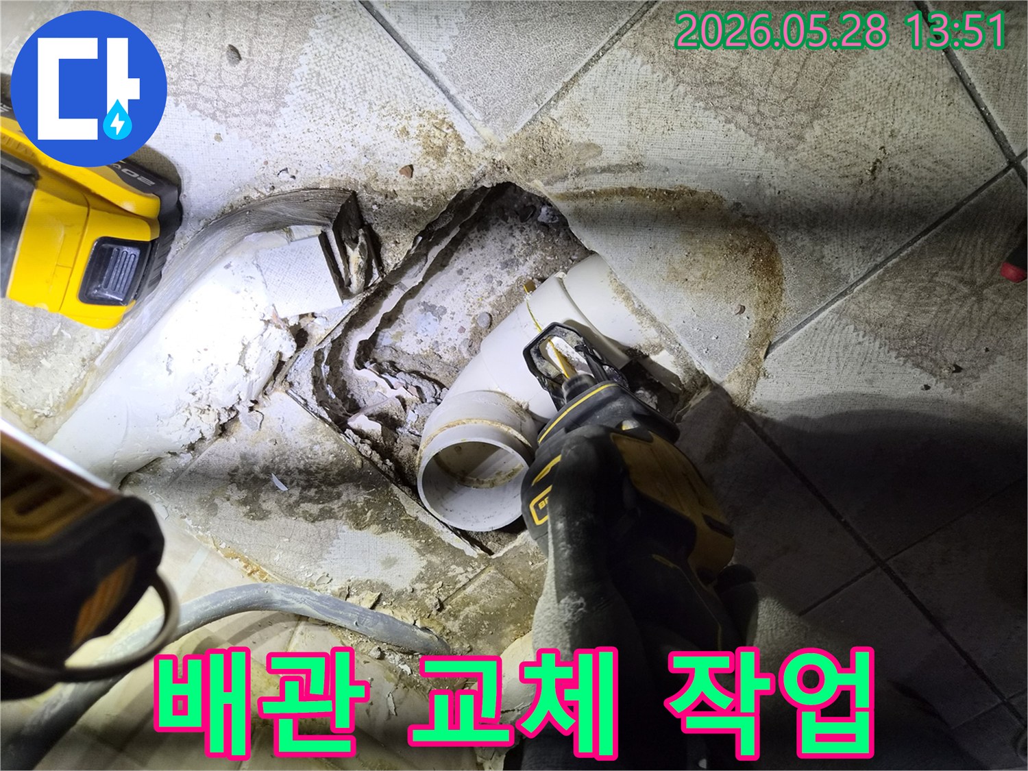 배관 파손으로 인한 누수 문제를 해결하고자-숙련된 기술자가-전동 공구를 사용하여-손상된 배관을 정밀하게 제거하고 있습니다.