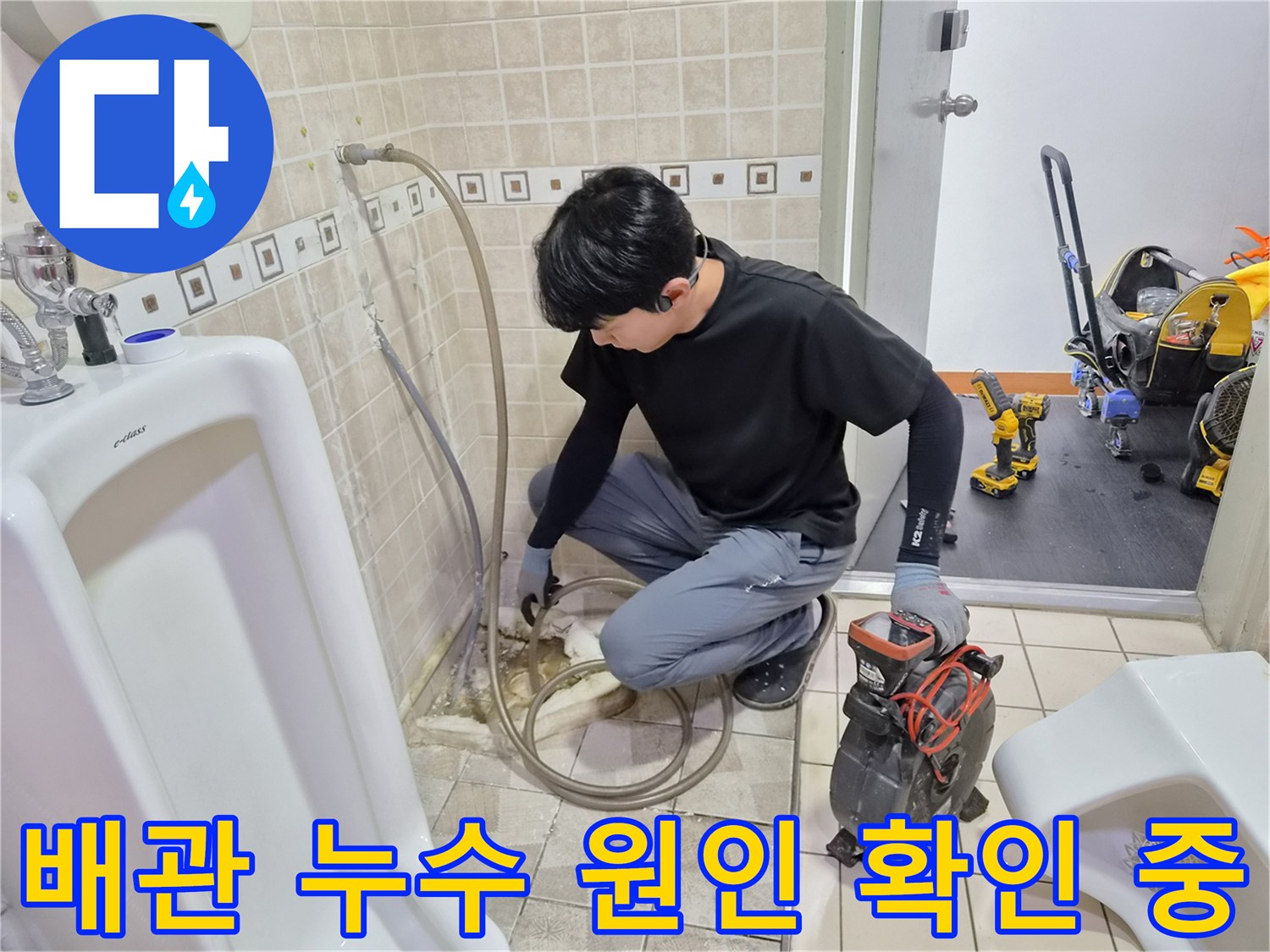소변기 하단 배관의 연결 상태와 물샘 여부를 진찰하고 있습니다.