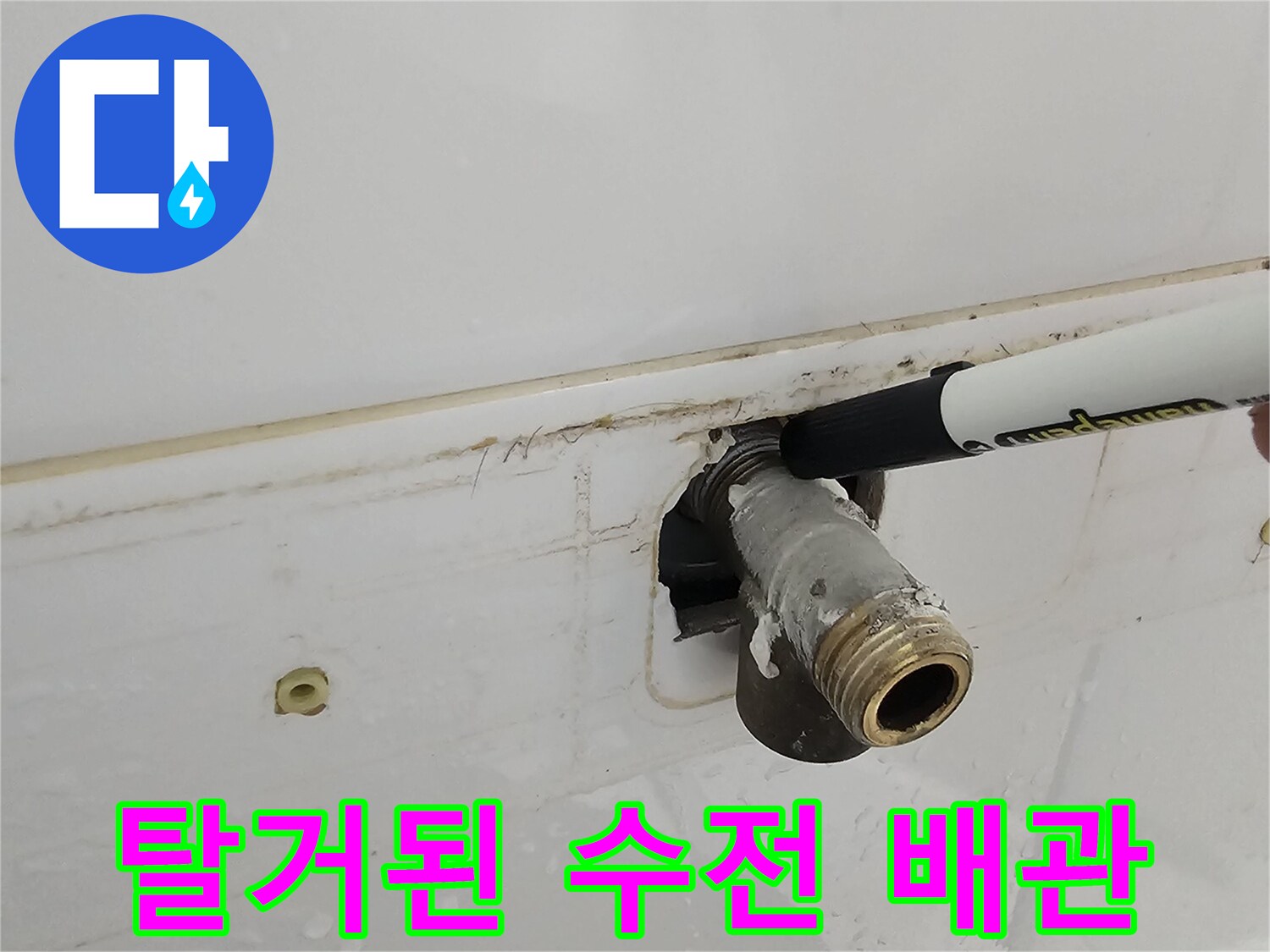 욕실 벽면에서 탈거된 샤워기 연결 배관의 근접 촬영 사진입니다.