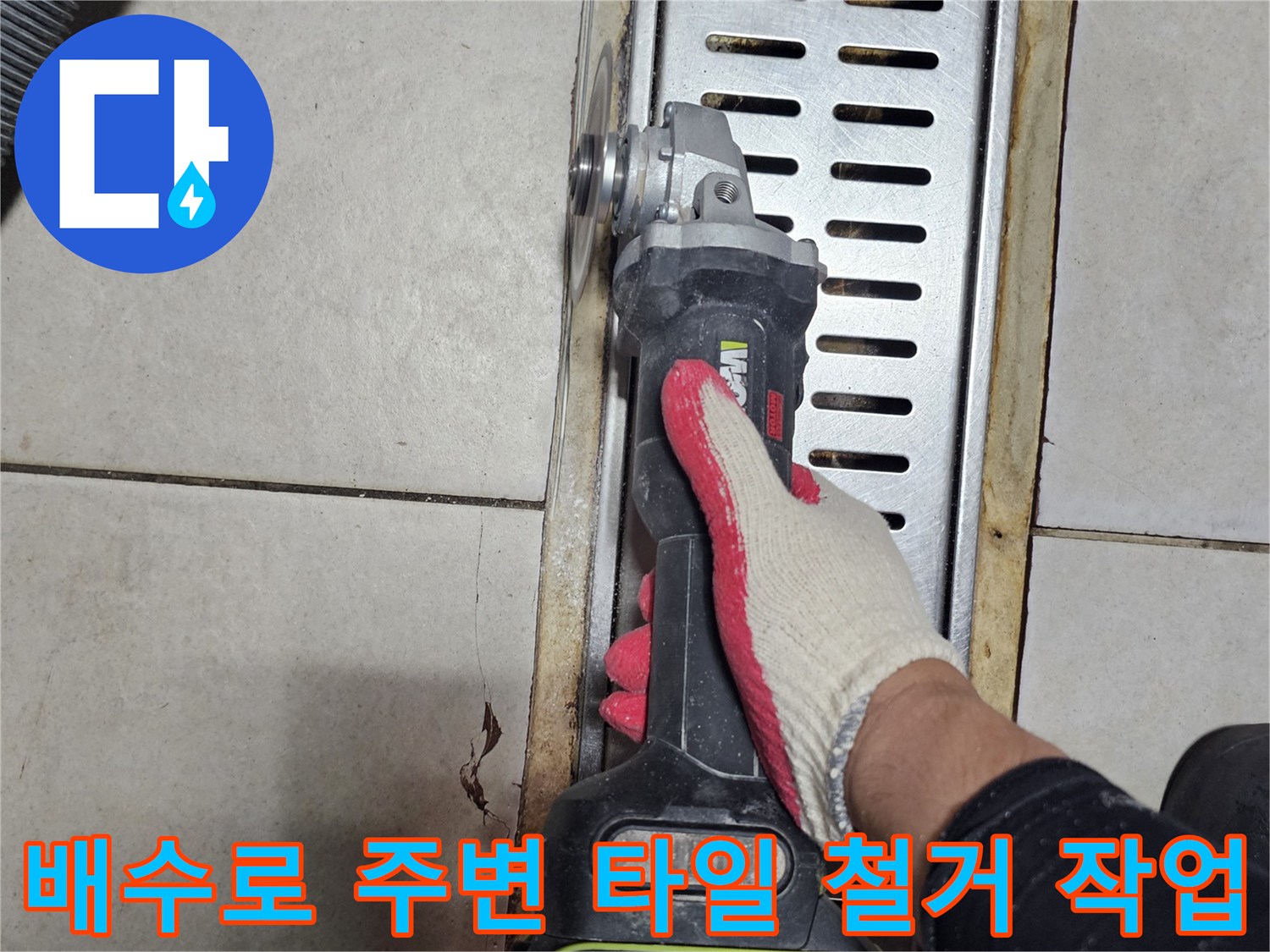 그라인더 장비를 사용하여 트렌치 옆쪽의 타일을 절단하고 있습니다.