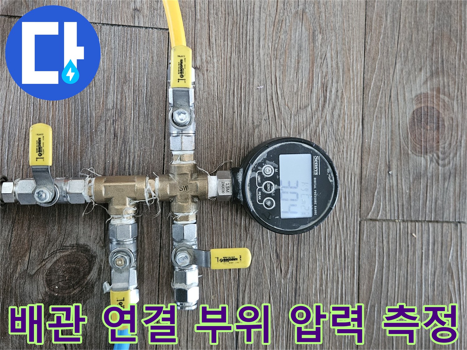 노란색과 파란색 호스가 연결된 배관 분기점의 압력계