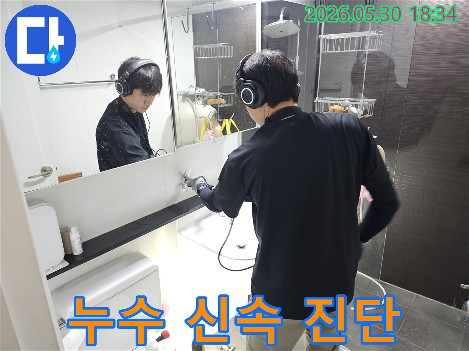 누수-전문가가-헤드셋을-사용하여-욕실-세면대-아래-배관의-누수-지점을-찾는-모습