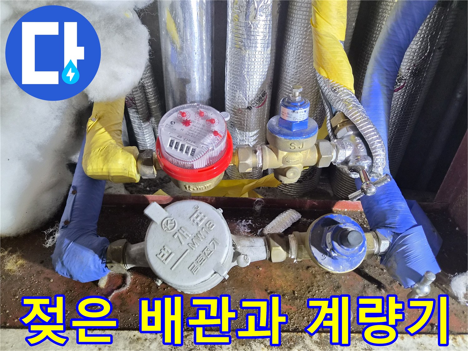물기가 맺혀 있는 수도 계량기와 노란색 배관 연결부