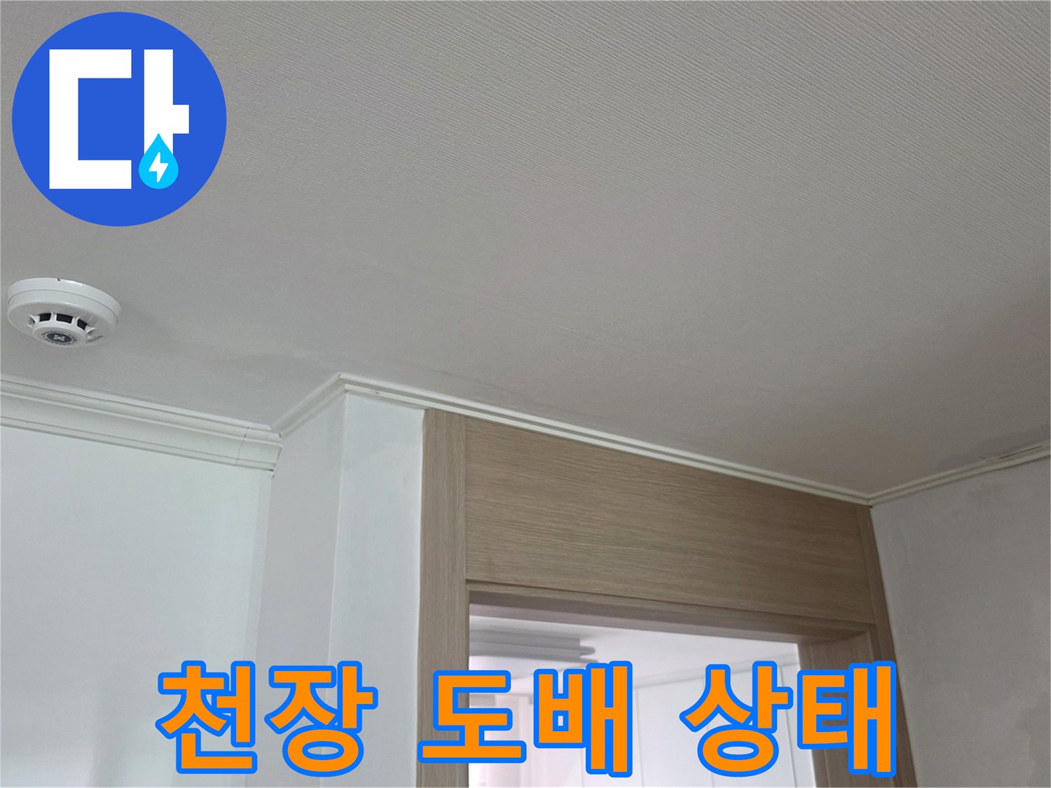 하얀색 천장 도배지와 화재감지기가 보이는 거실 내부