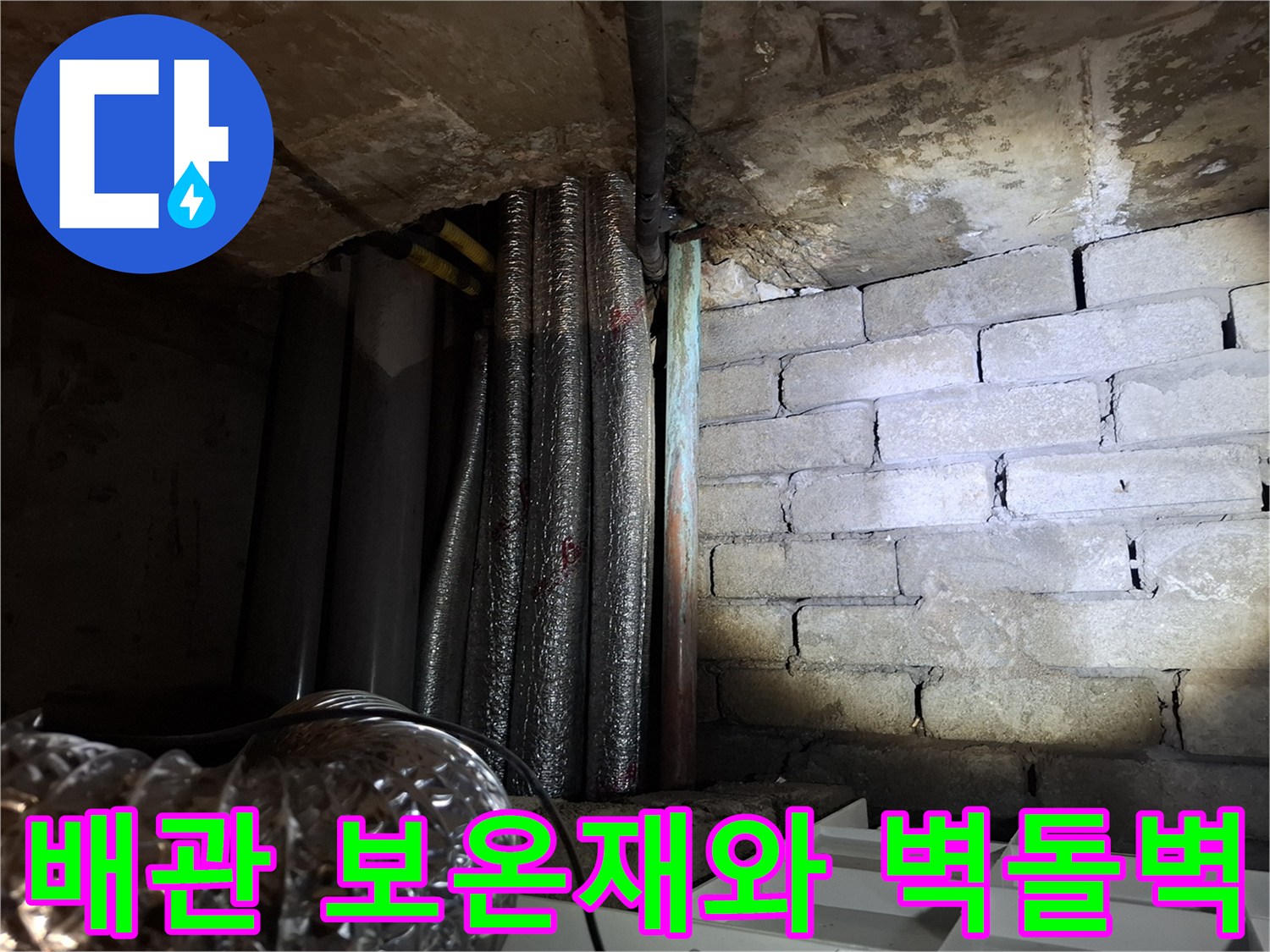 천장 내부-보온재로 마감된 배관과 거친 벽돌 표면