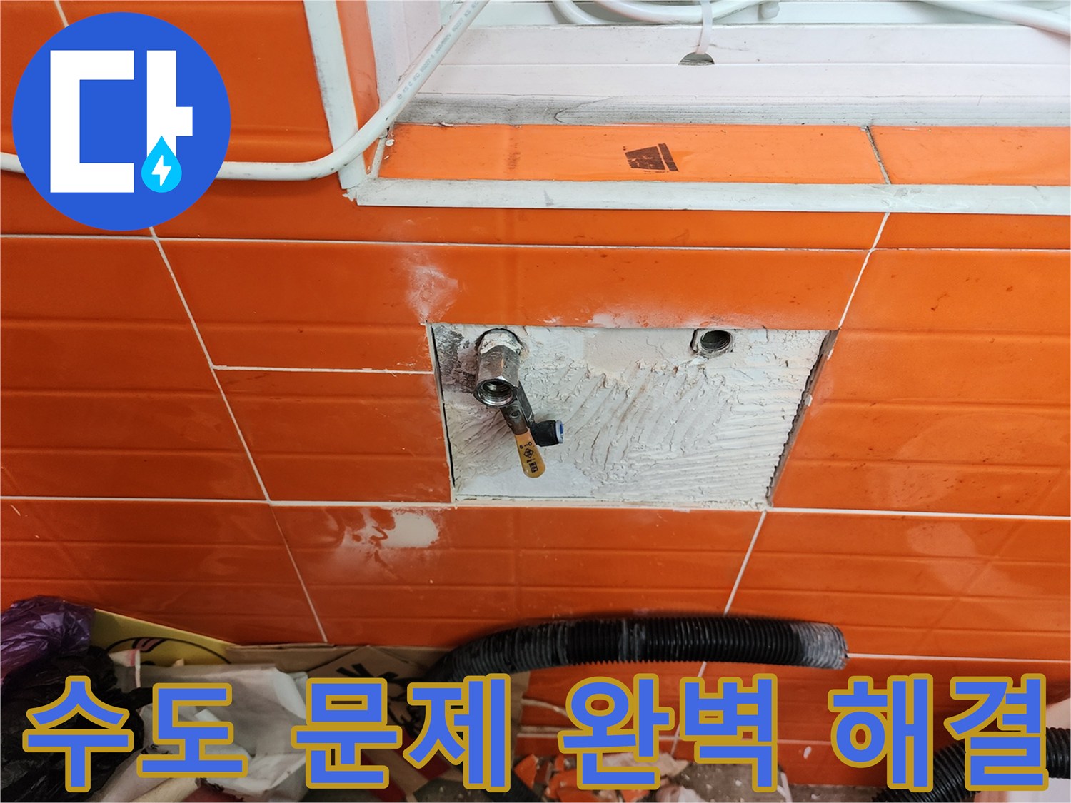 오렌지색 타일 벽면의-수도 문제를 완벽하게 해결하기 위해-타일을 제거하고-배관을 수리하는 작업 현장