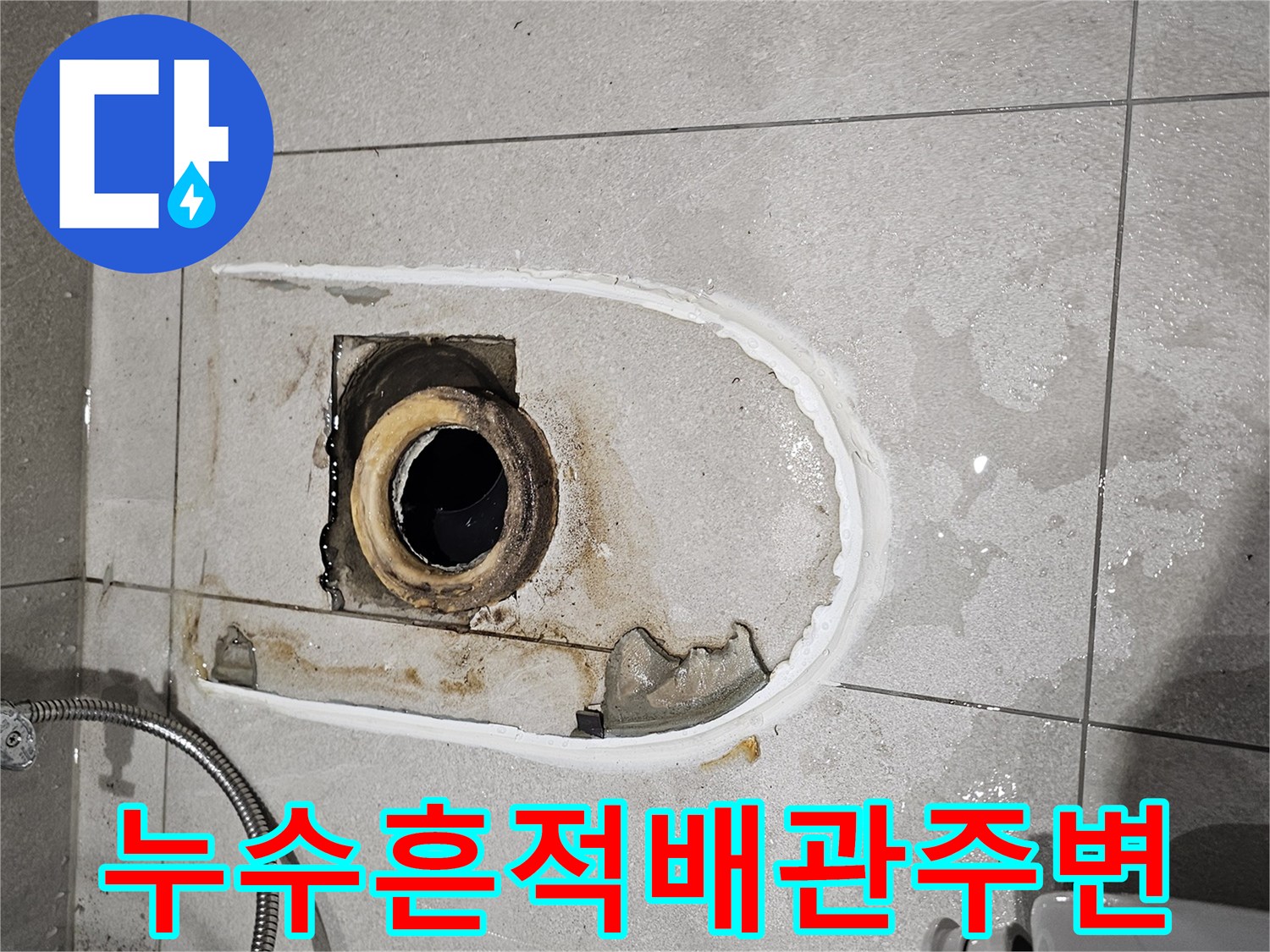 변기 제거 후 드러난 젖은 바닥 타일과 배관 입구 부위