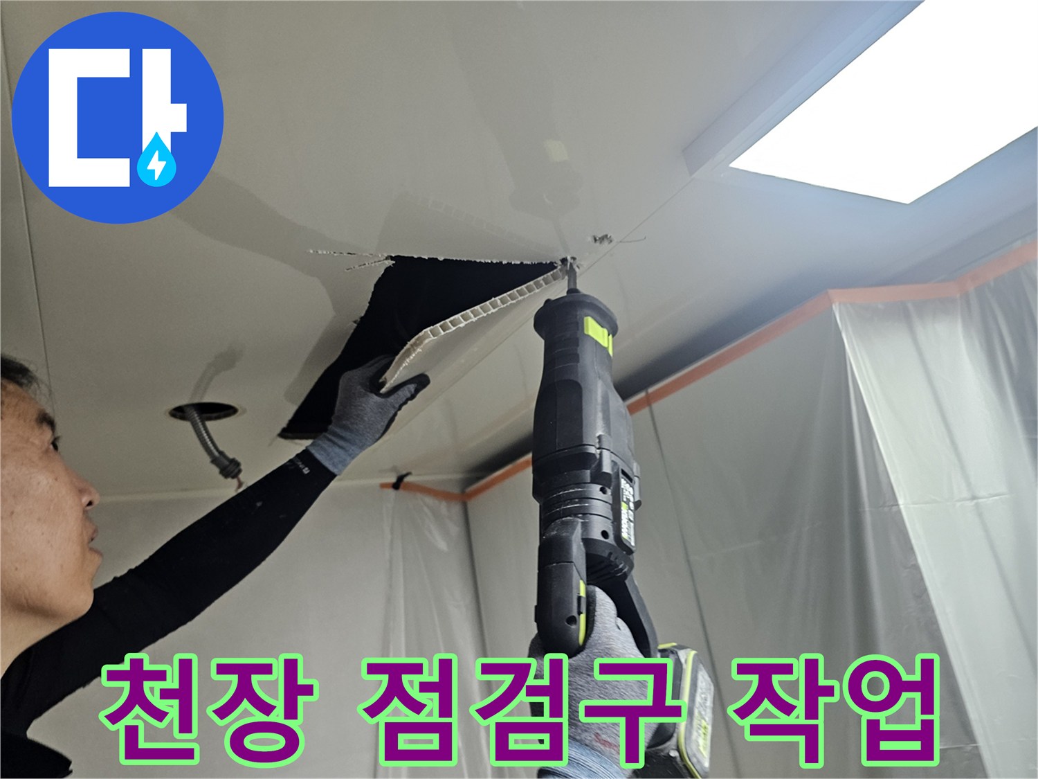 점검구를 열고 천장 내부를 확인하는 기술자의 모습